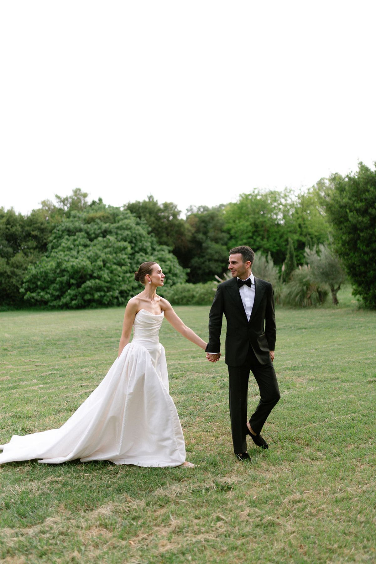 Clara and Constantin walk hand in hand across the lawn