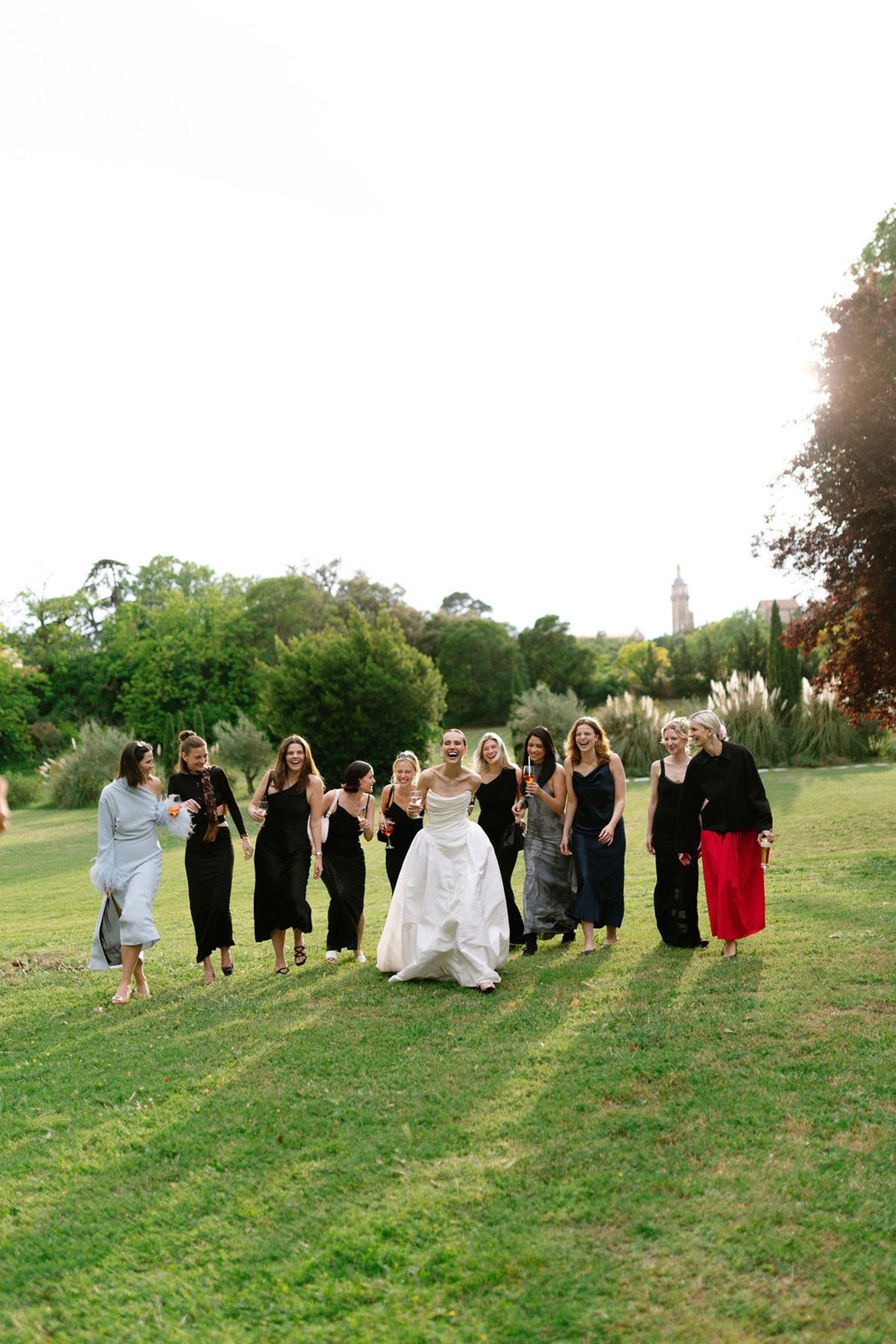 The bridal party gathers on the lawn with the bastide visible behind them