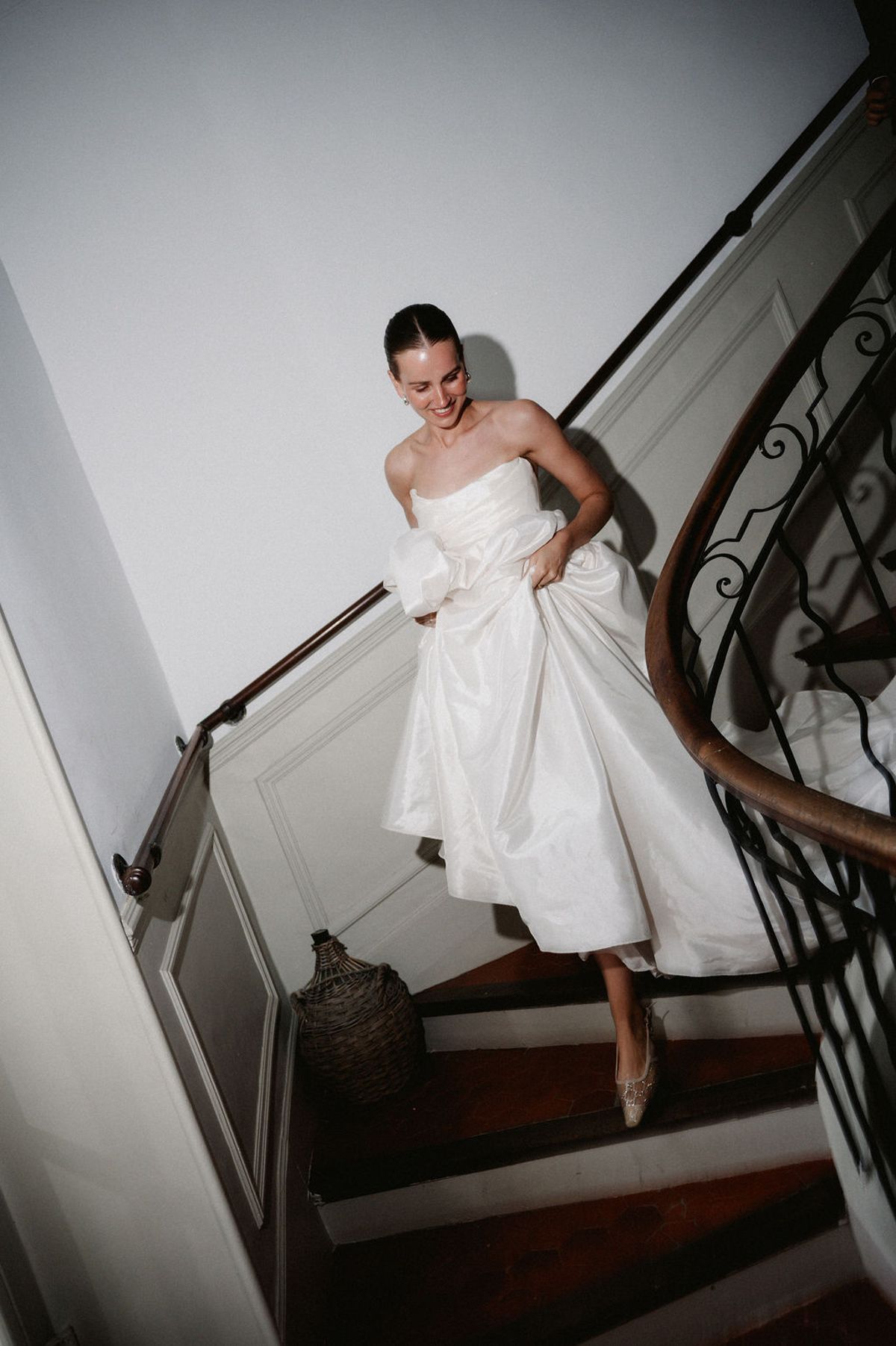 Clara descends the spiral staircase at Bastide de Toursainte