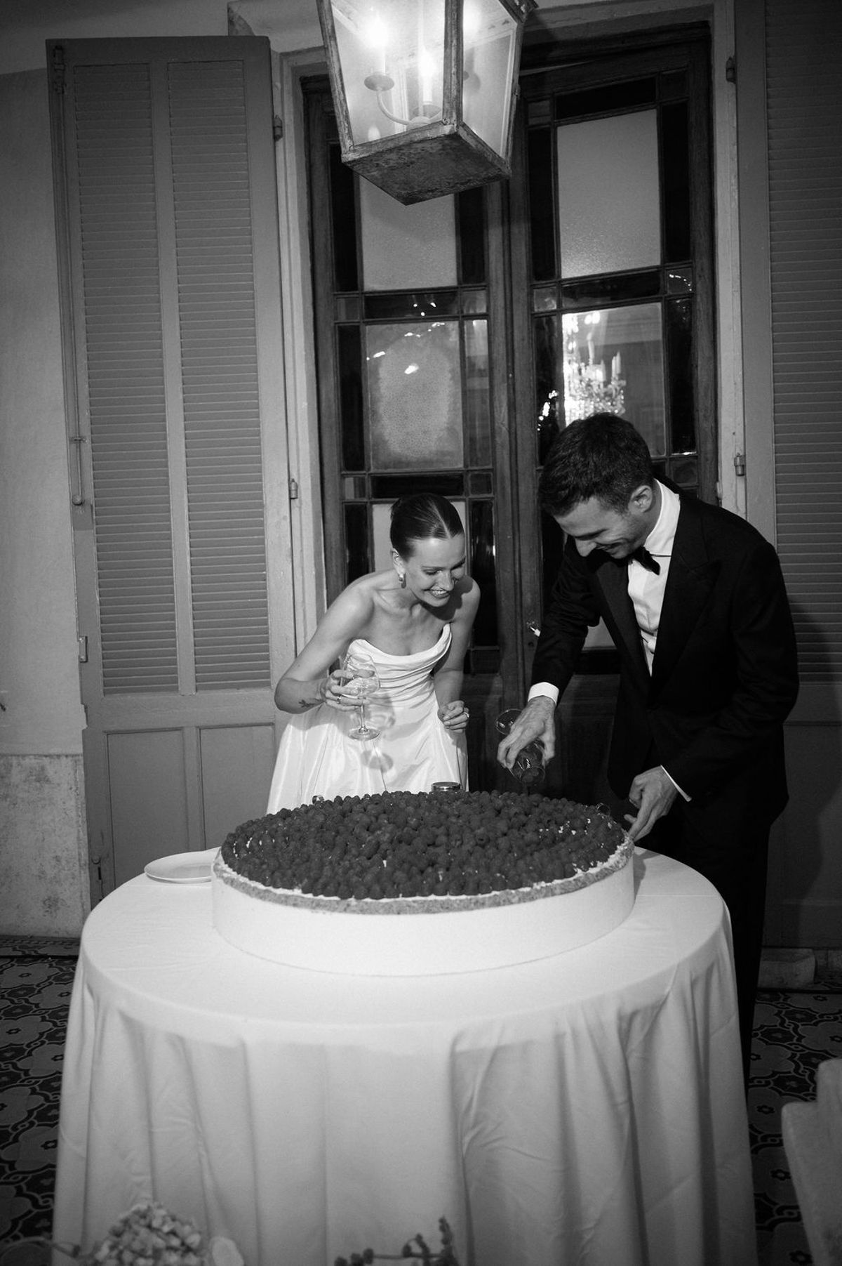Clara and Constantin cut the wedding cake, captured in black and white