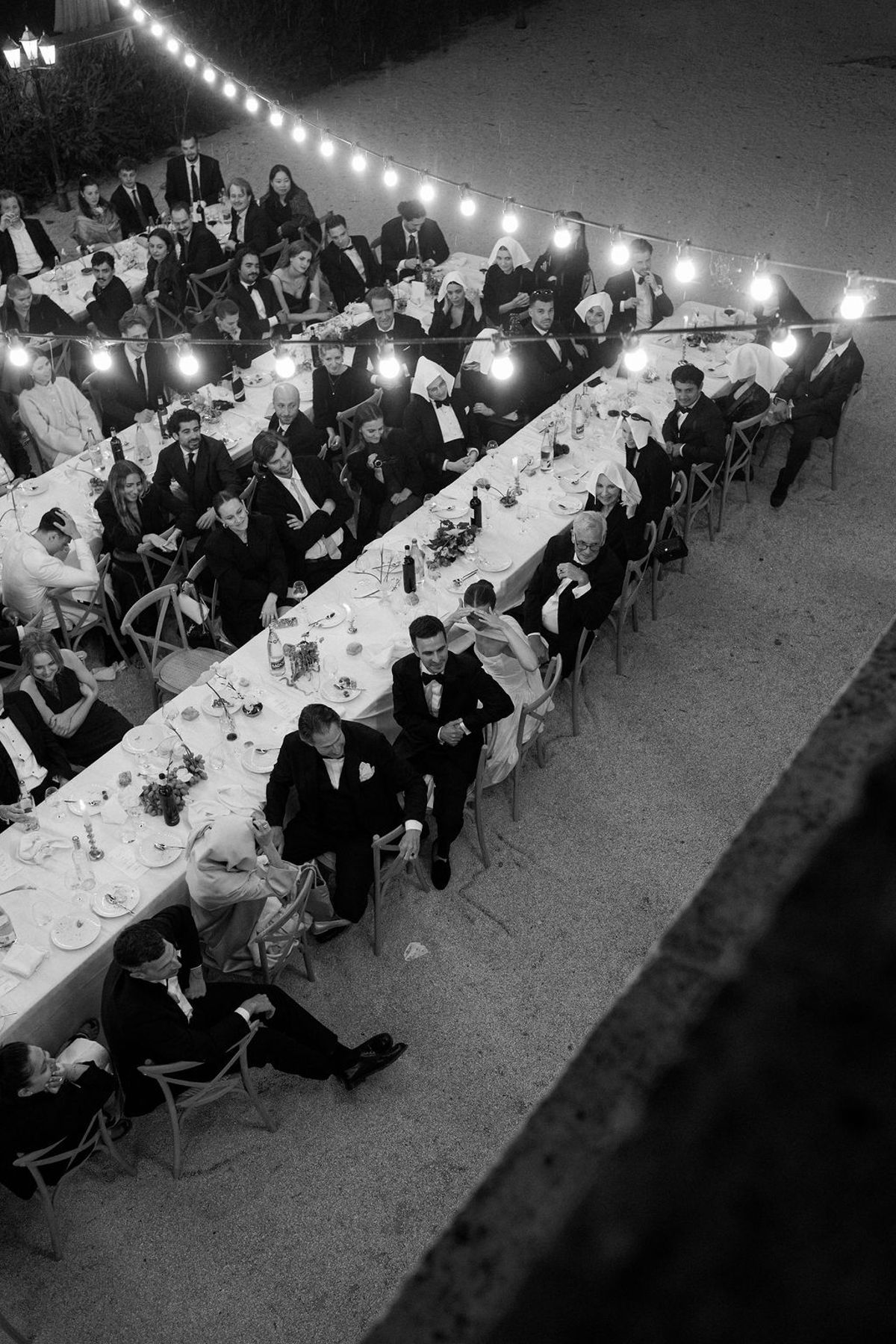 The long dinner table filled with guests, captured in black and white