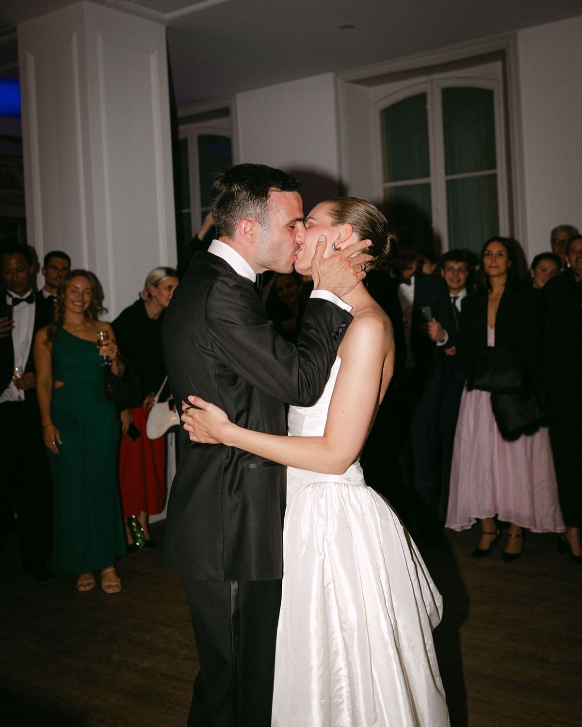 Clara and Constantin kiss as guests gather around them