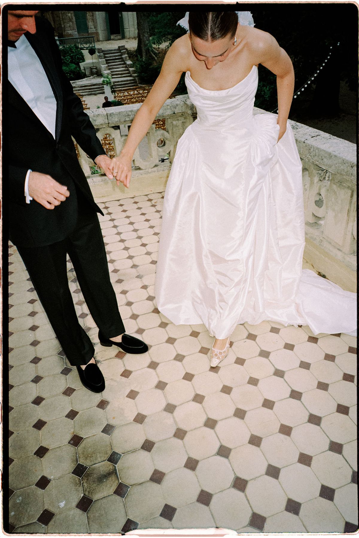 A close view of Clara's dress hem on the tiled floor