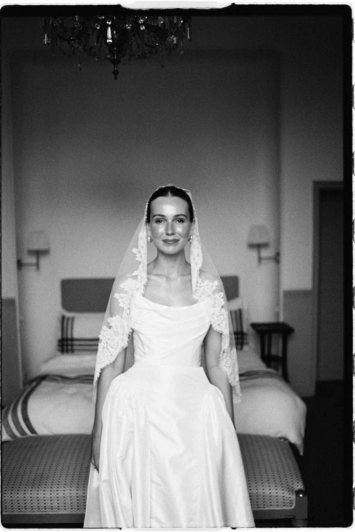 Clara stands for a portrait in her veil, captured in black and white