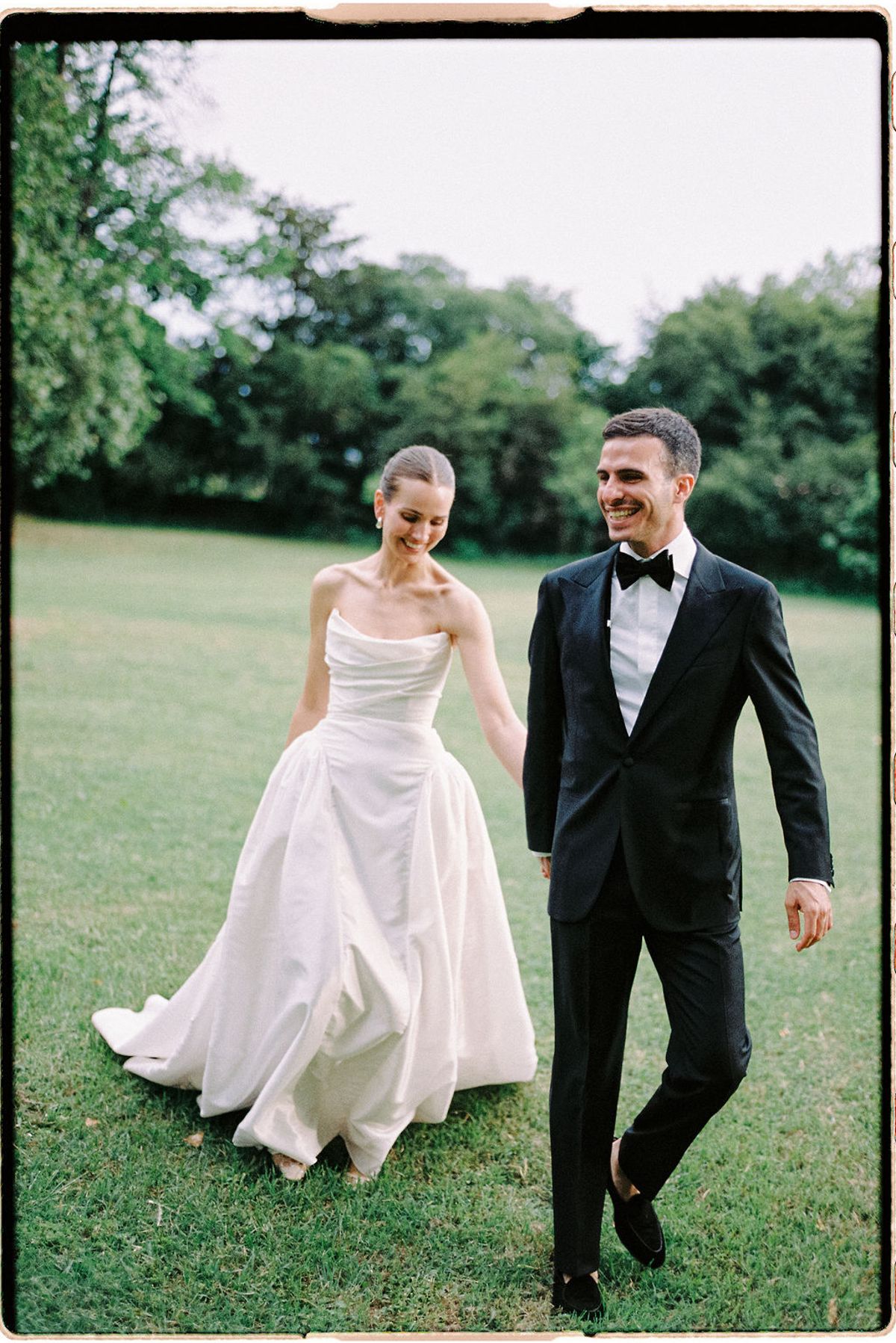 Clara and Constantin walk hand in hand across the lawn