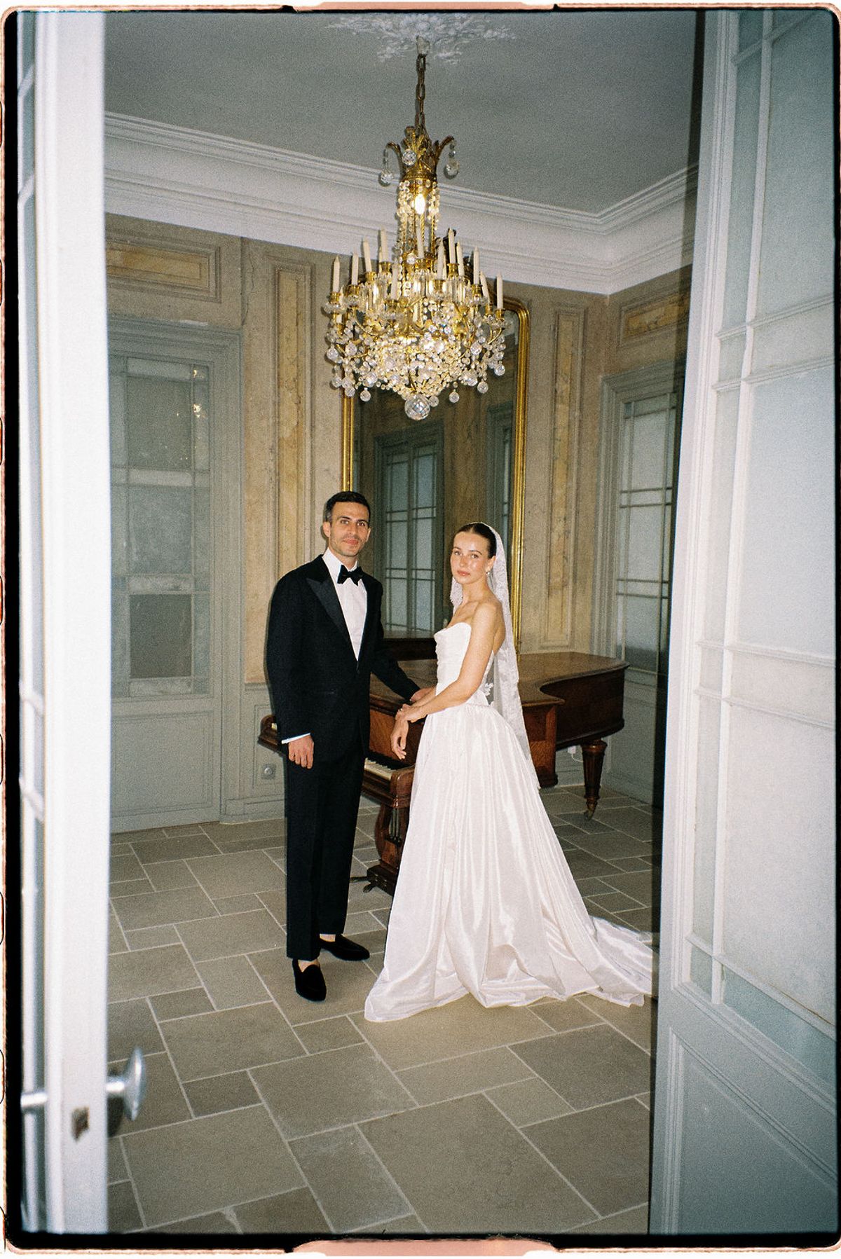 Clara and Constantin stand beside a piano inside Bastide de Toursainte