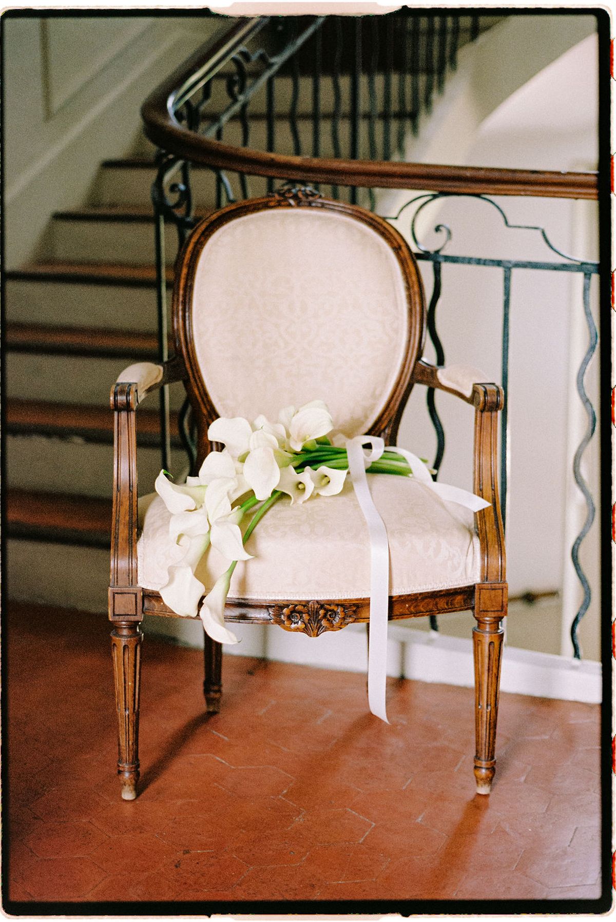 A ceremony chair dressed with a calla lily bouquet