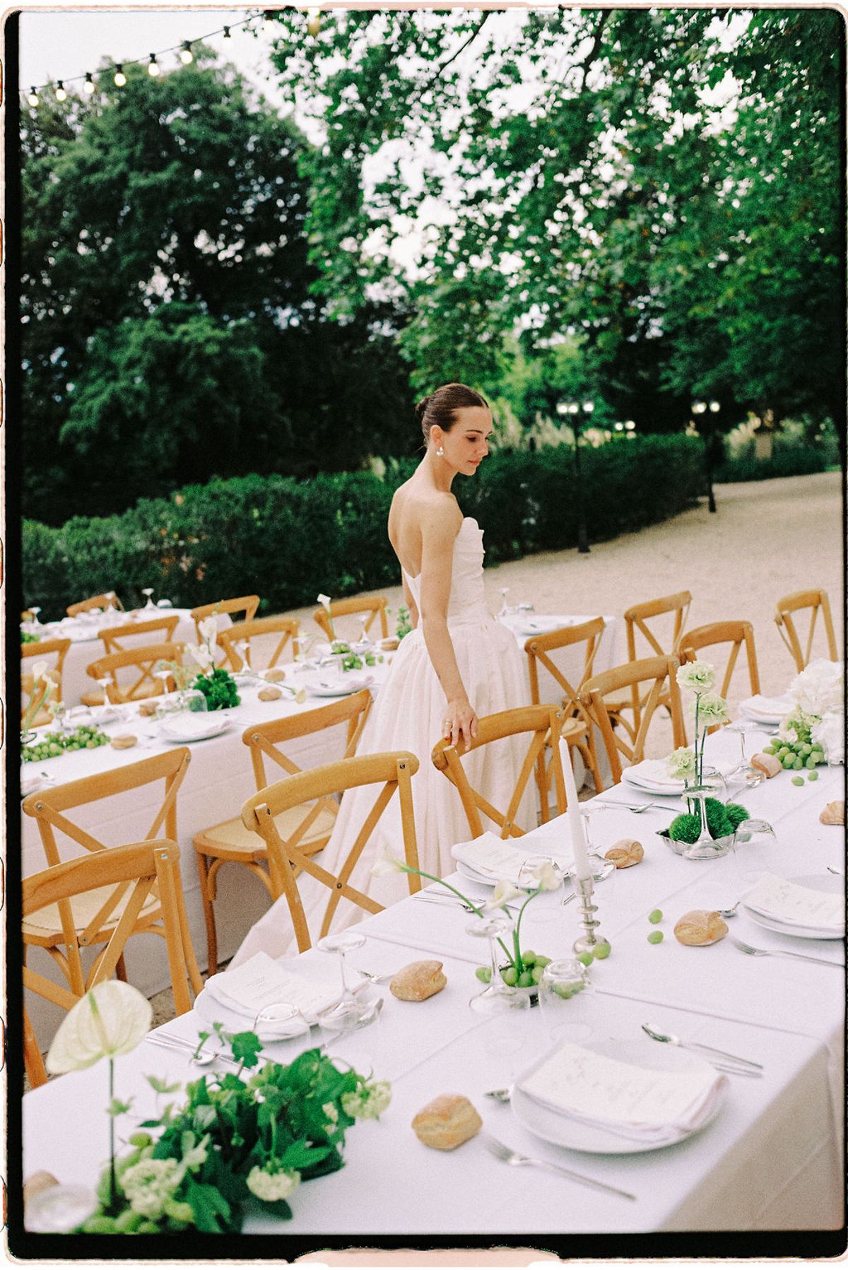 Clara walks alone past the long dinner table set for the reception