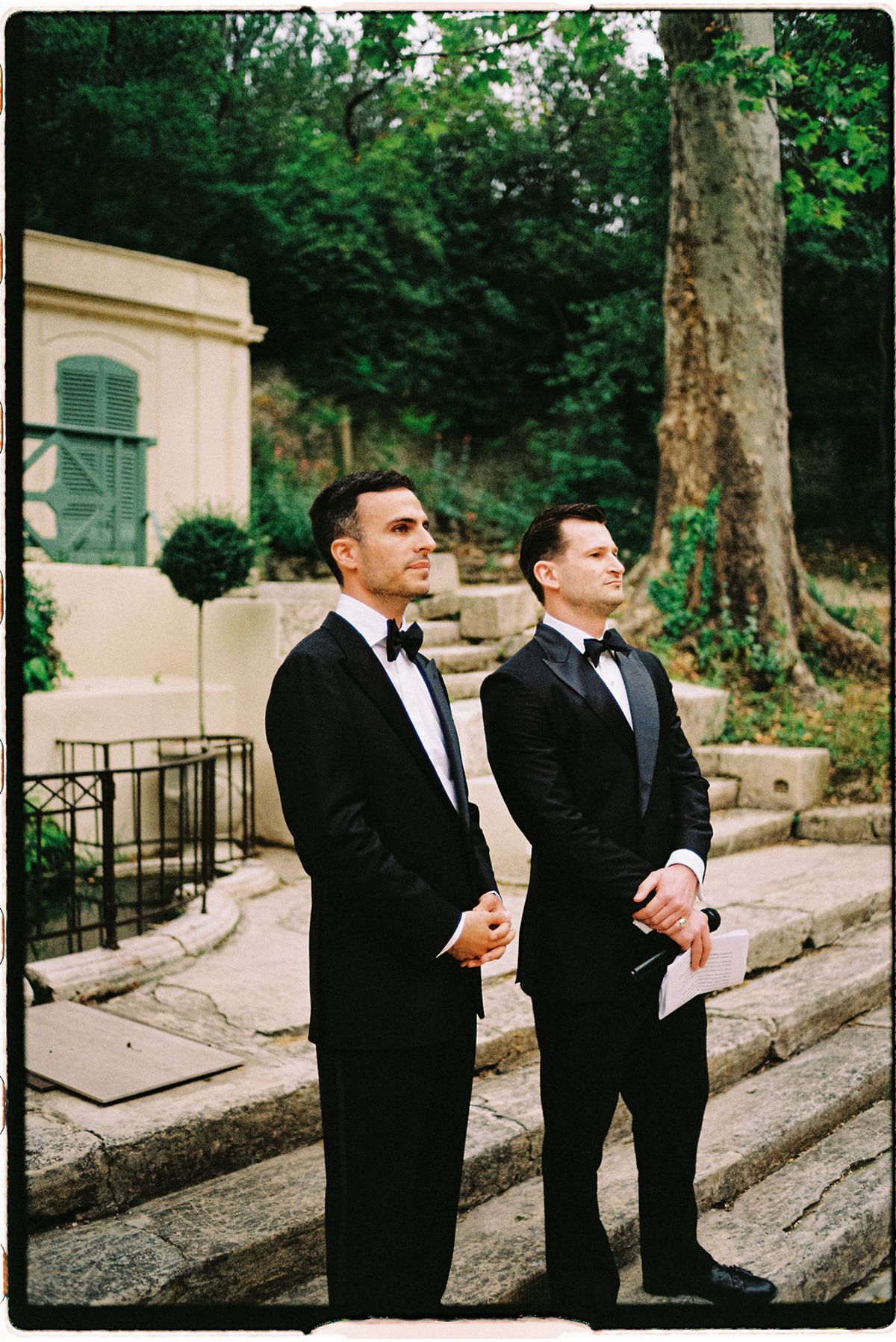 Two groomsmen share a candid moment in the park