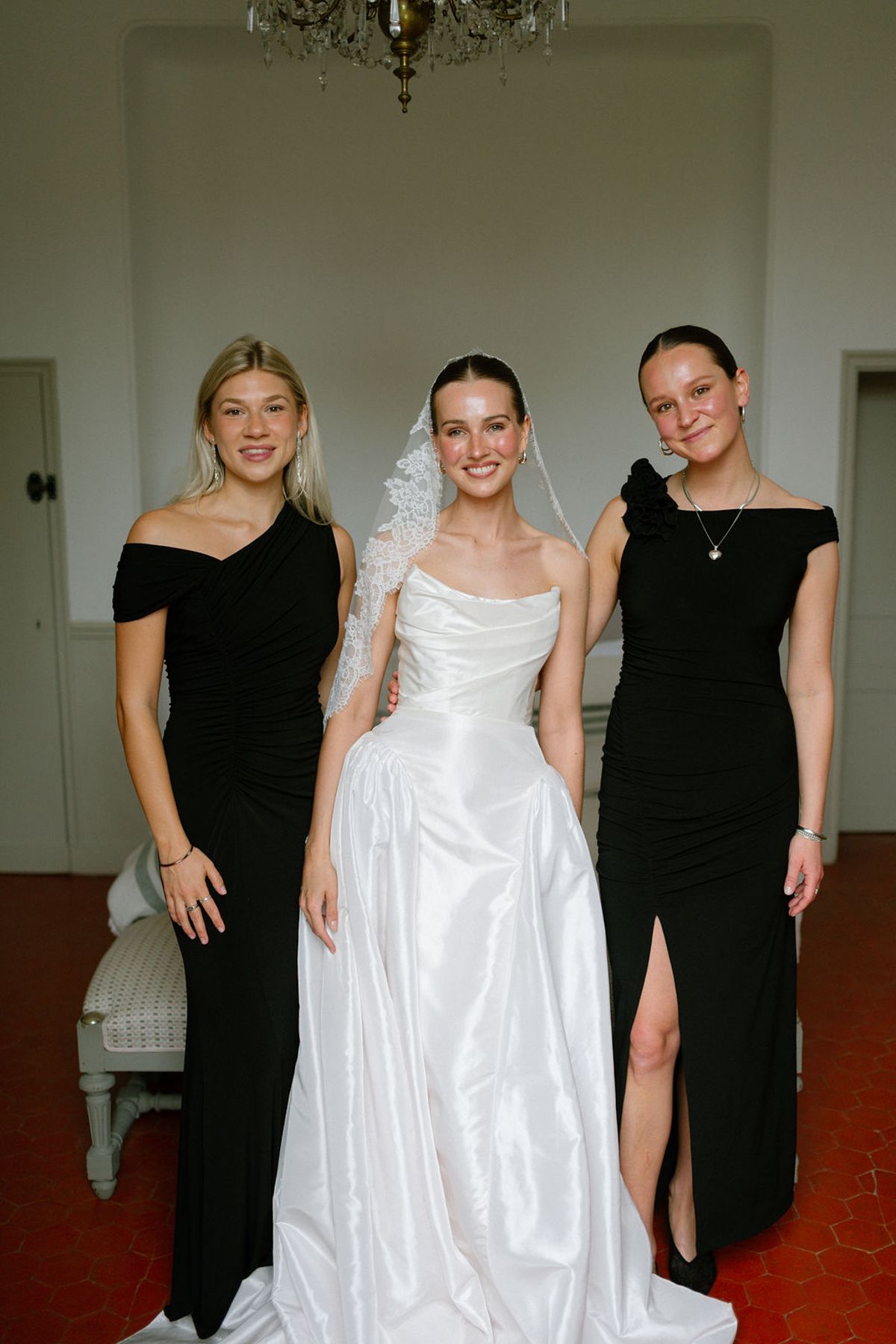 Clara stands with two bridesmaids in black dresses