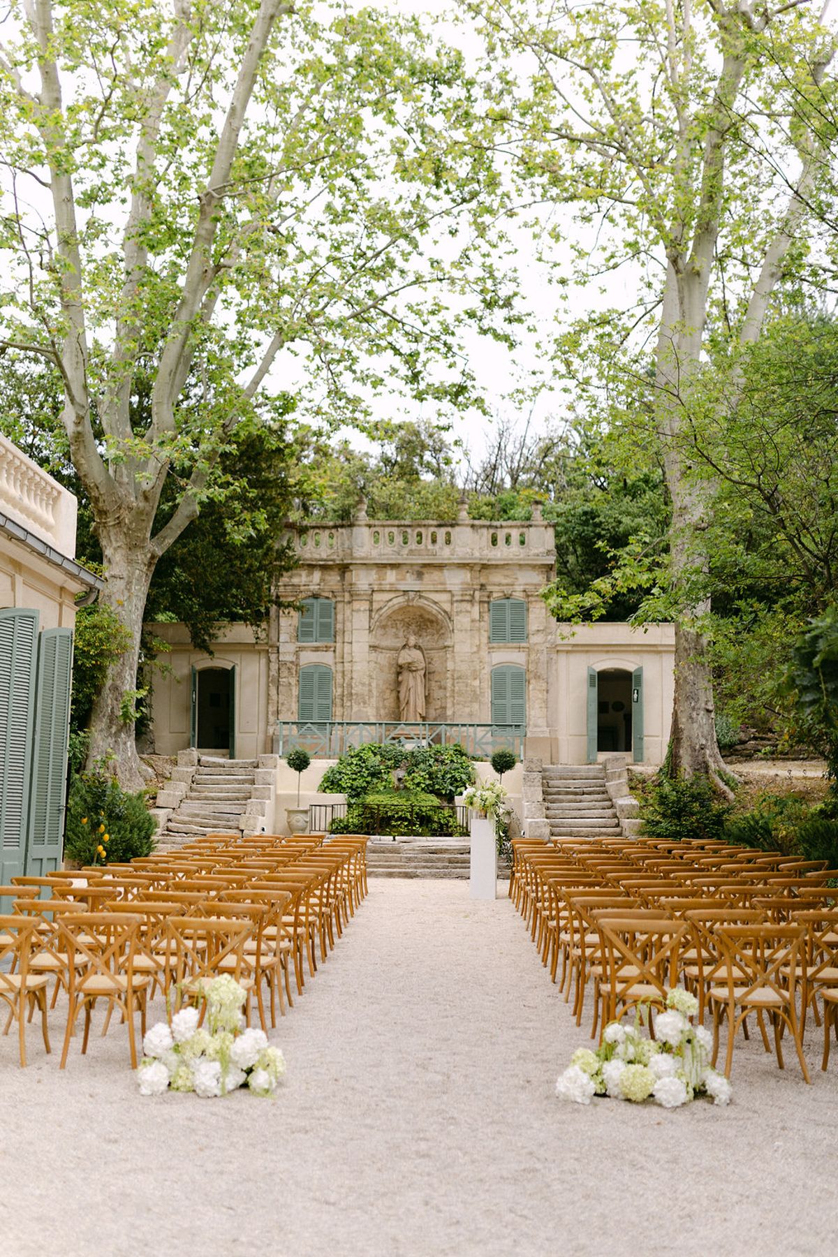 Rows of empty chairs set for the outdoor ceremony in the park at Bastide de Toursainte