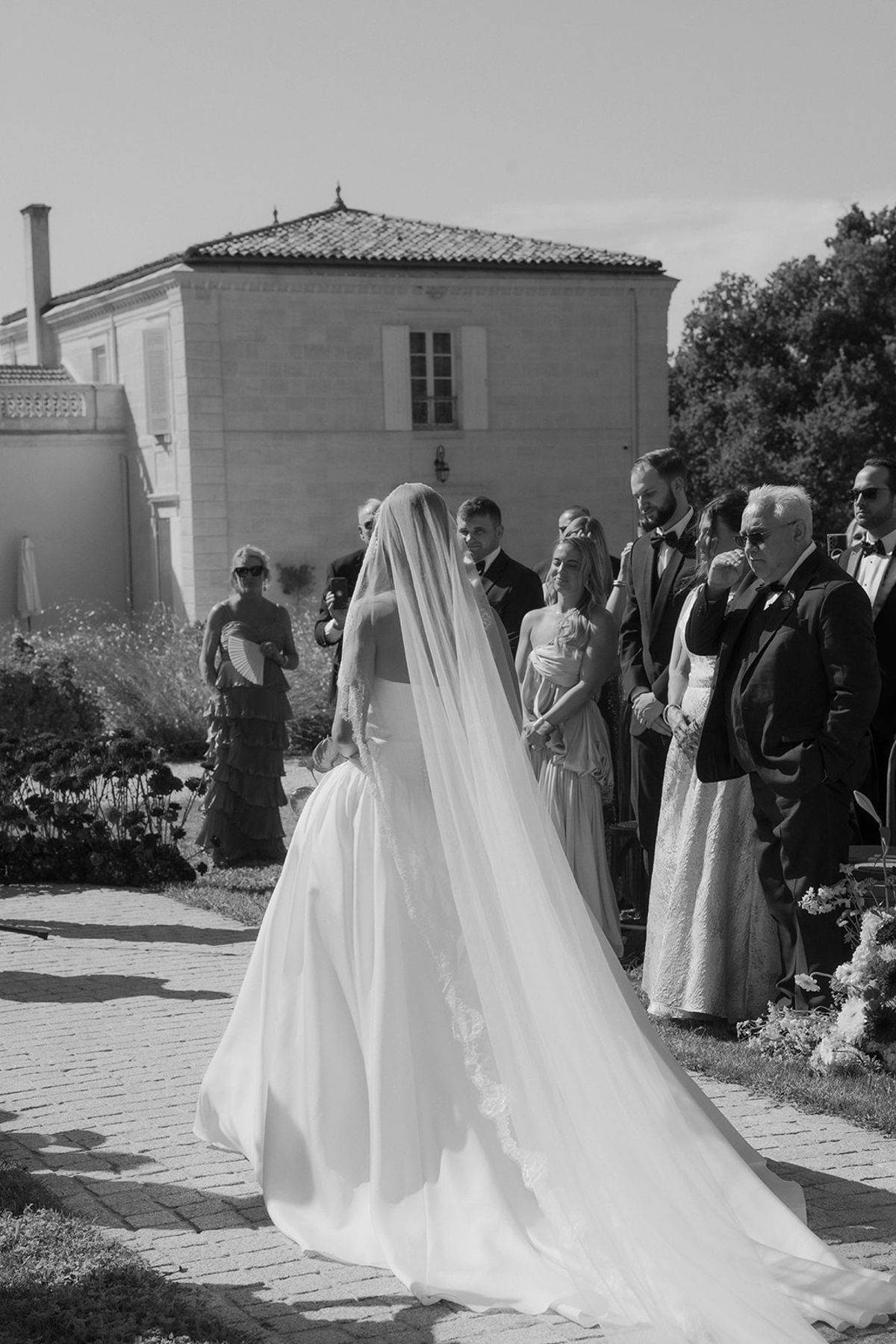 Kendra walking down the aisle in her long veil, black and white