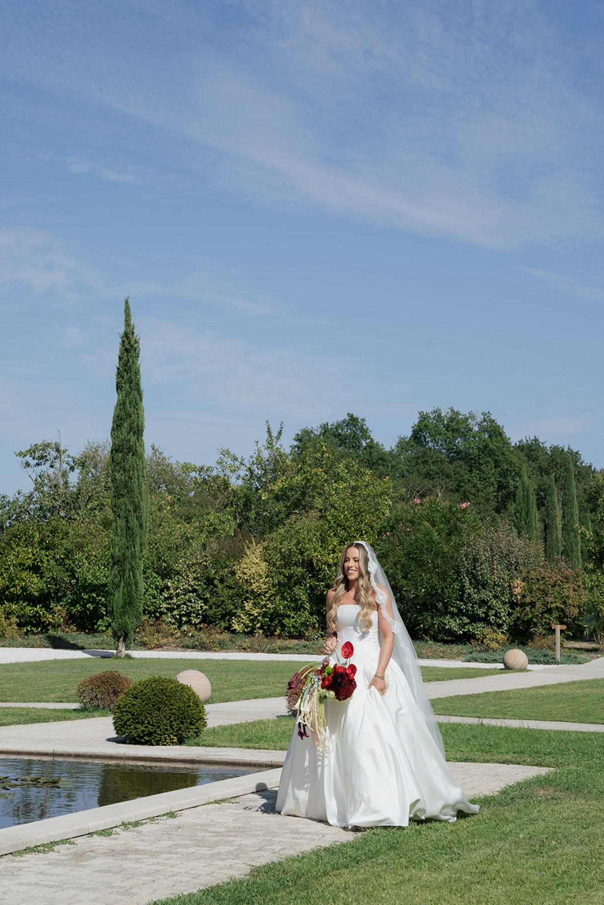Kendra with her bouquet by the formal garden pond