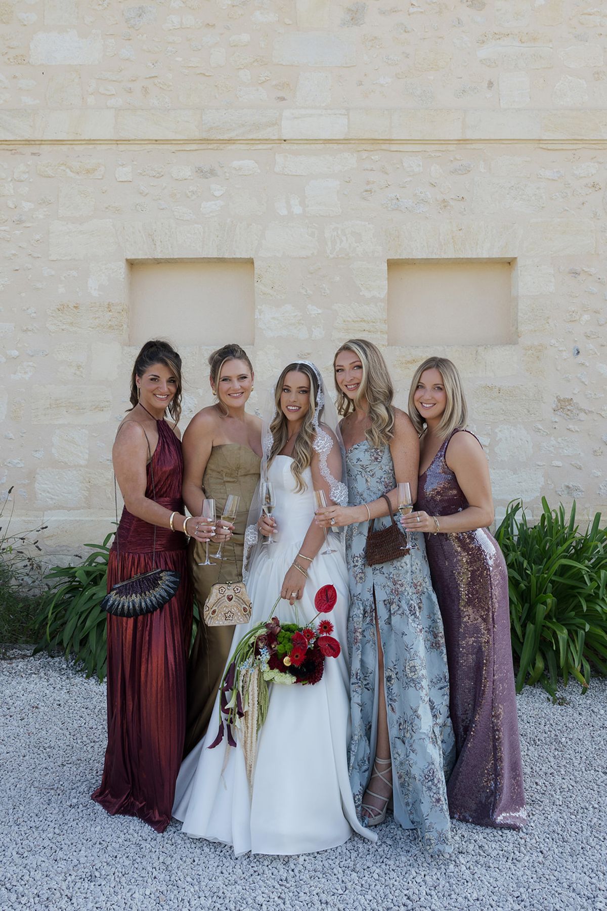Kendra and her bridesmaids against the stone wall of the château