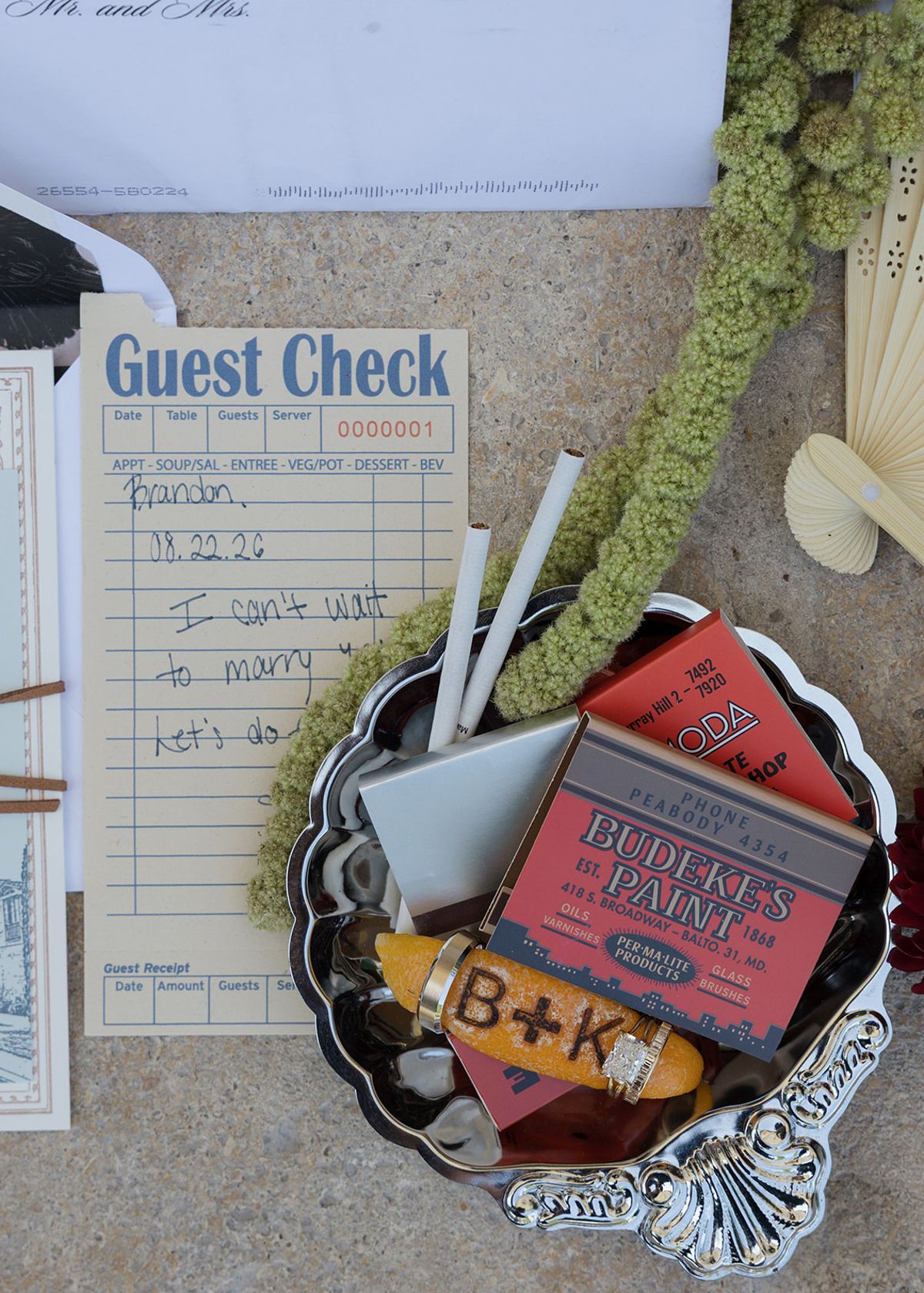 A guest check and a silver dish with B+K matches and cigars