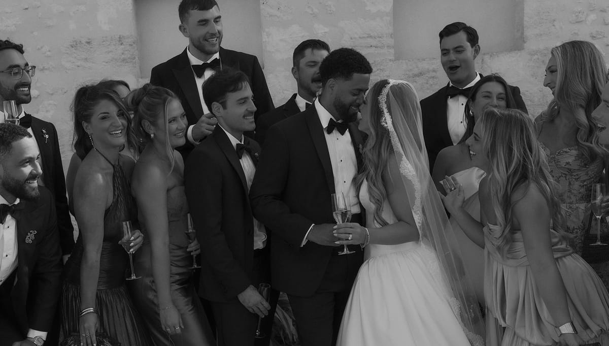 Kendra and Brandon laughing with their bridal party in black tie and long dresses