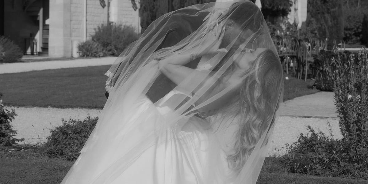 Kendra and Brandon beneath her veil, black and white