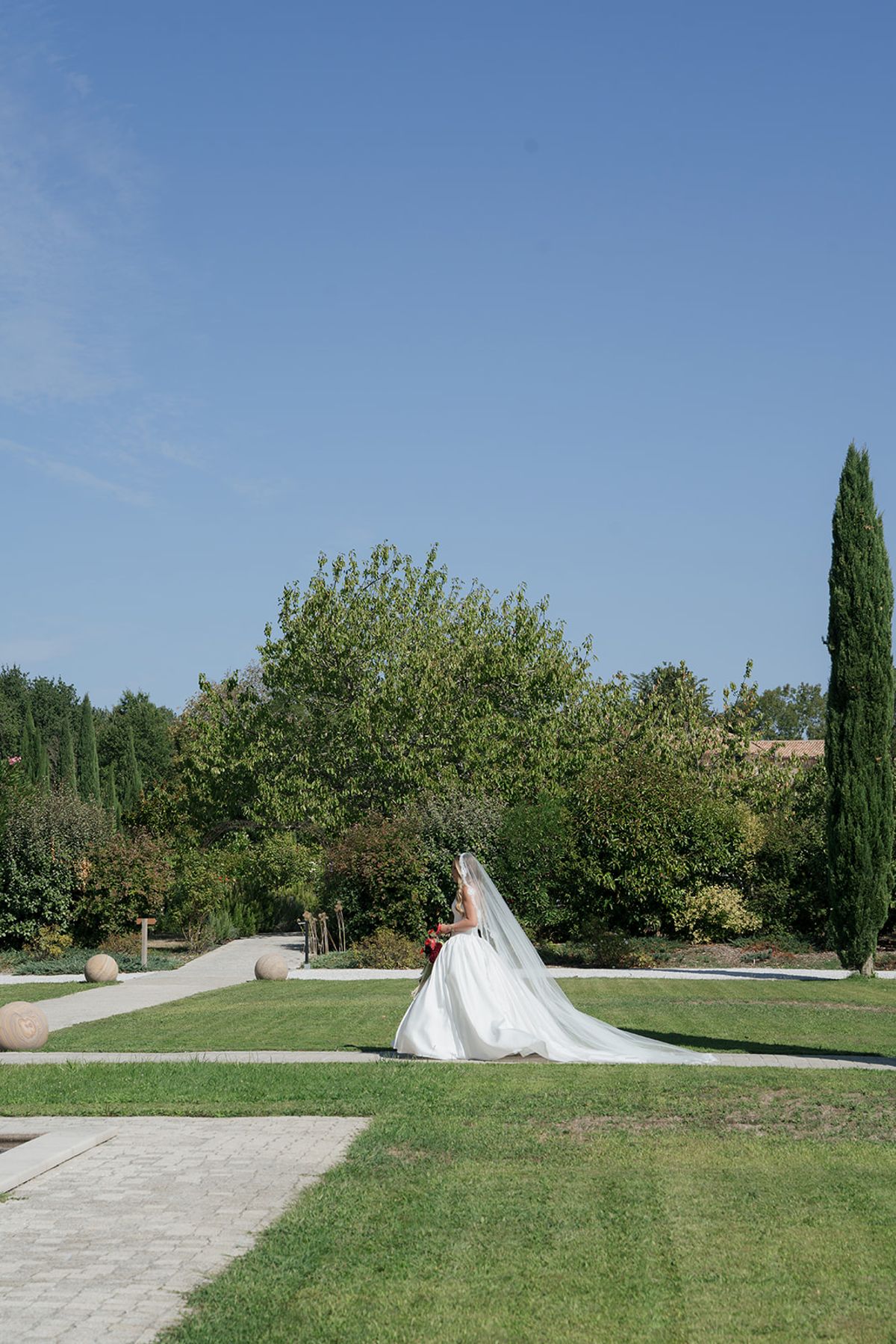 Kendra walking through the garden with her long veil