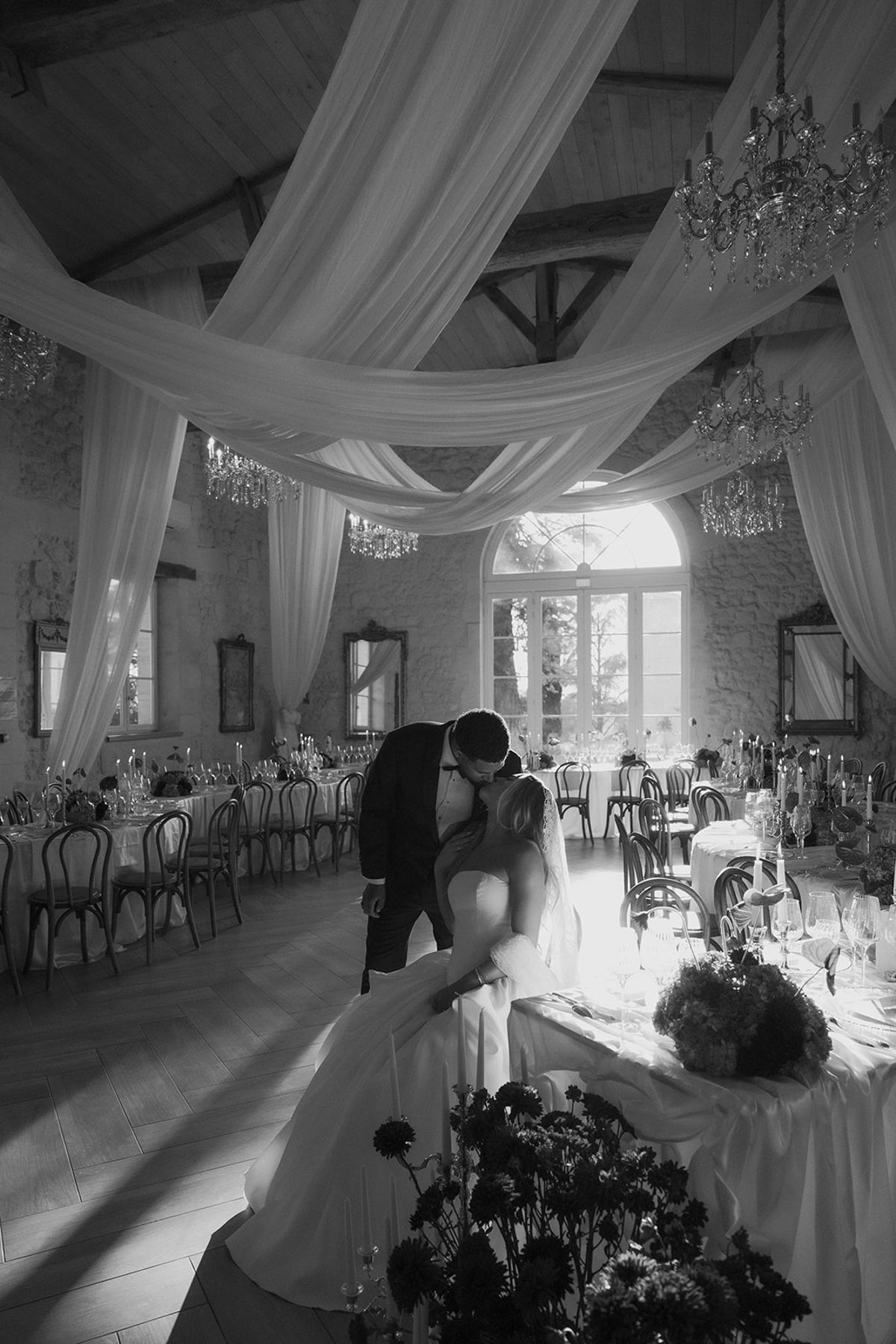 Kendra and Brandon kissing in the draped reception room, black and white