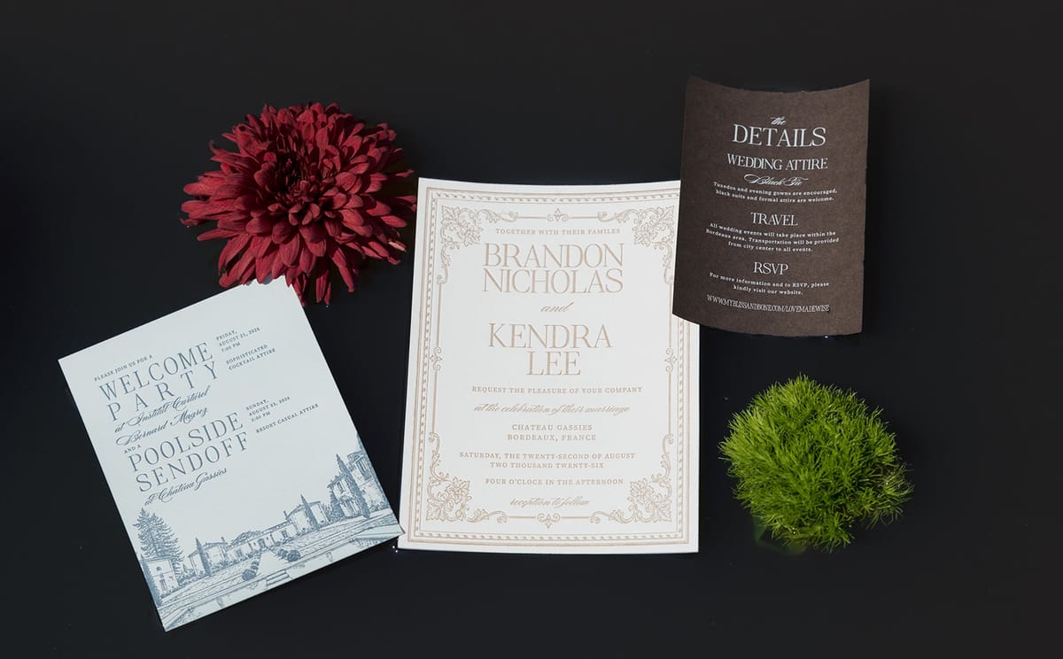 The wedding invitation suite on black with a red dahlia