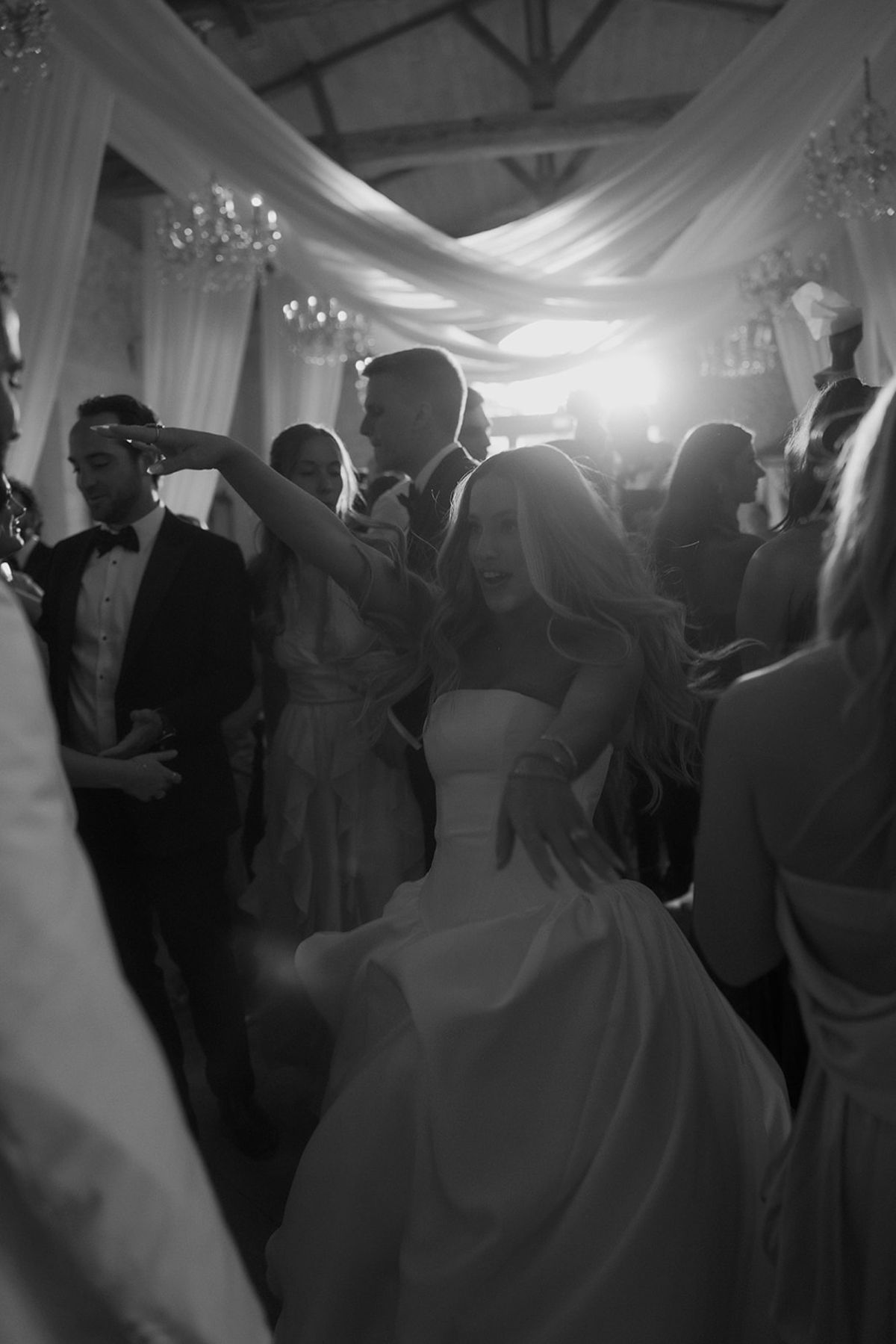 Guests dancing under the draped ceiling, black and white
