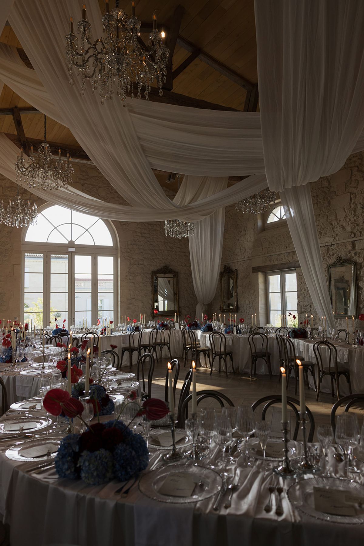 The reception room with arched windows, drapery and chandeliers