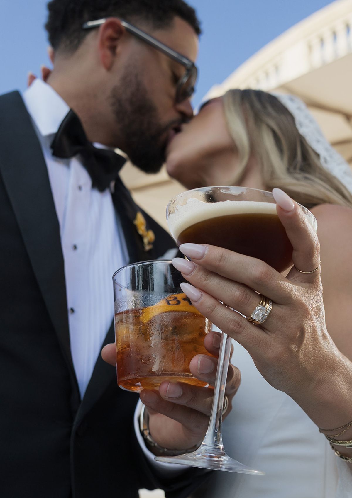 Kendra and Brandon kissing while holding drinks