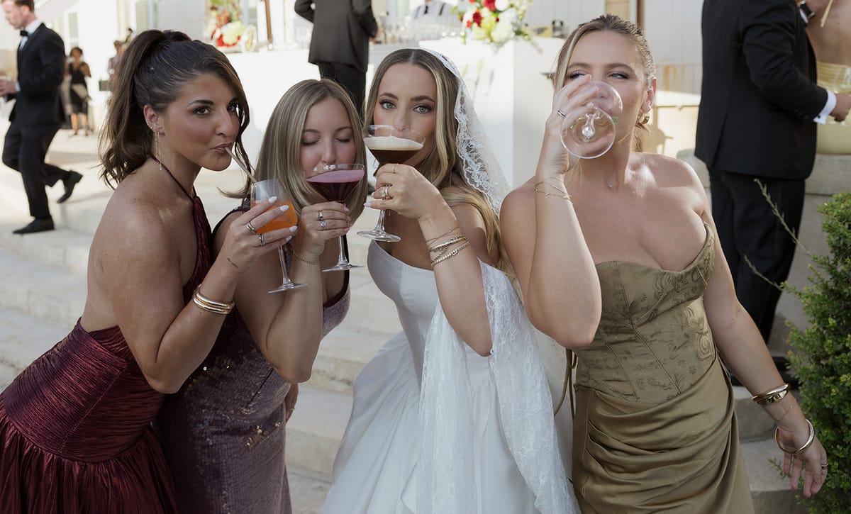 Kendra and her bridesmaids drinking from stemmed glasses