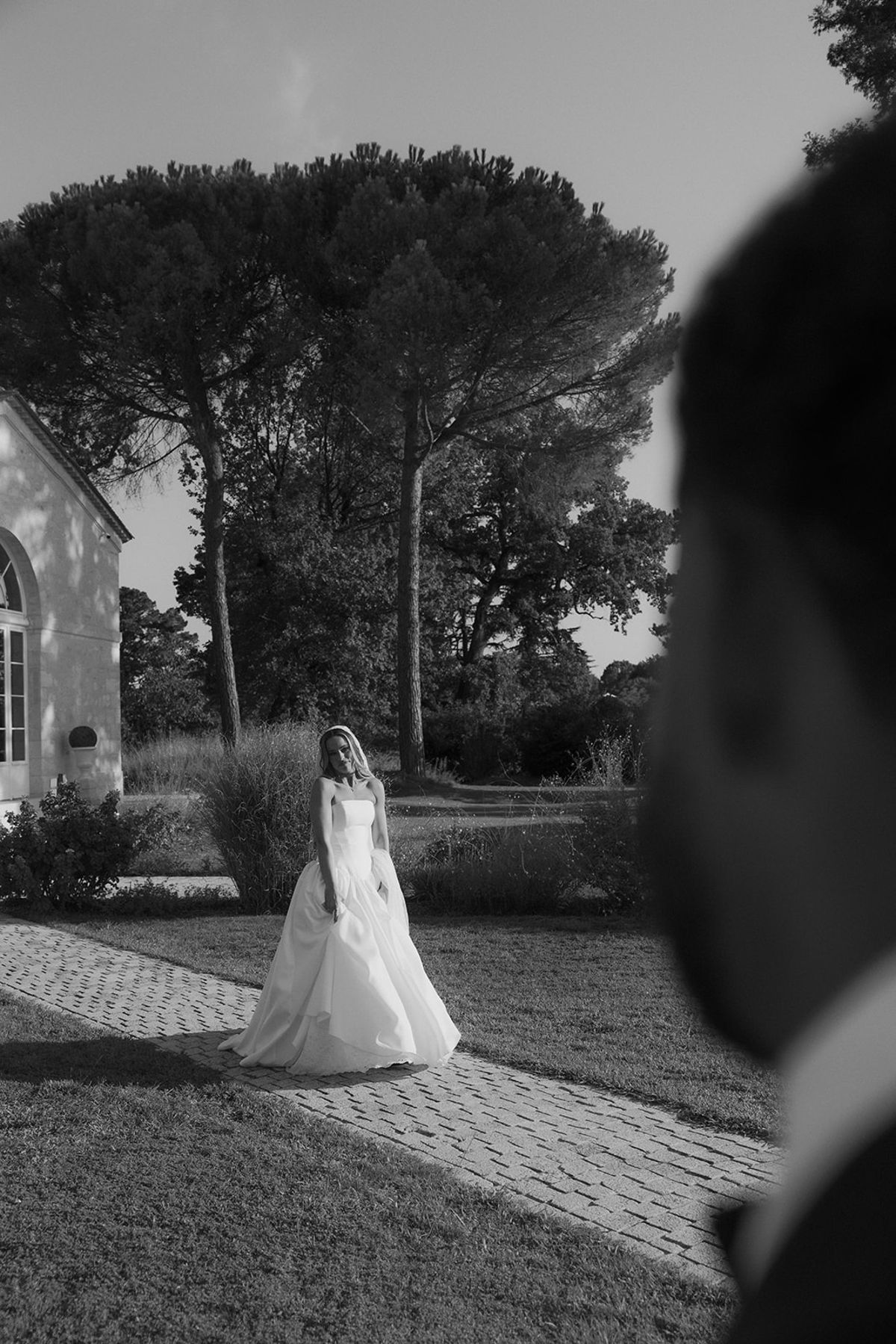 Kendra walking across the lawn towards Brandon, black and white