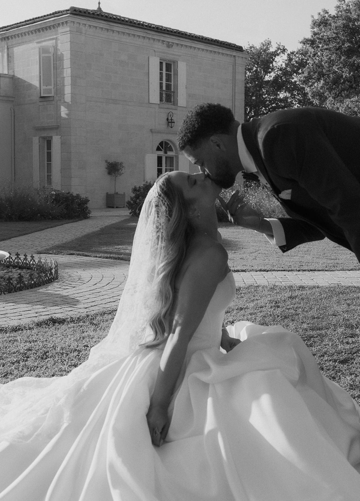 Brandon kissing Kendra on the lawn, black and white