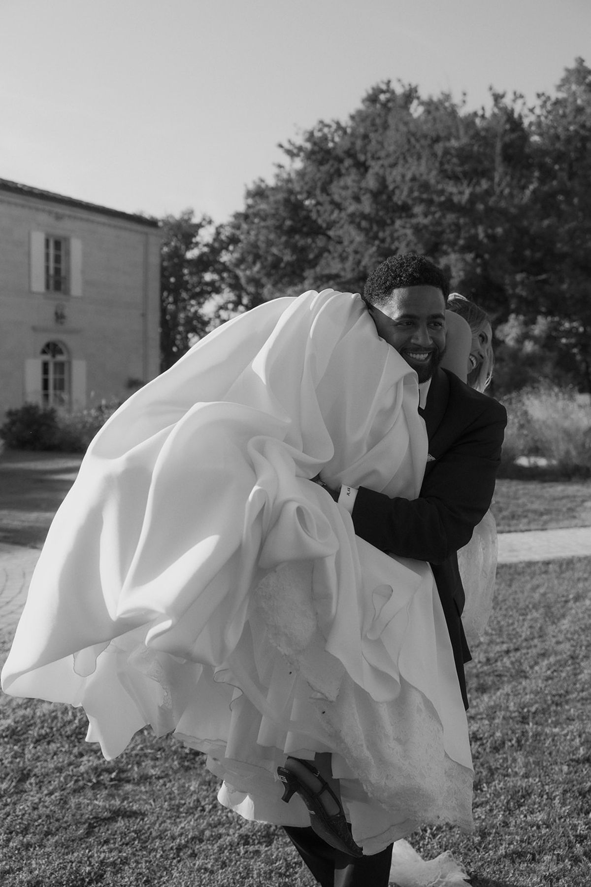Brandon lifting Kendra's skirt as they embrace, black and white