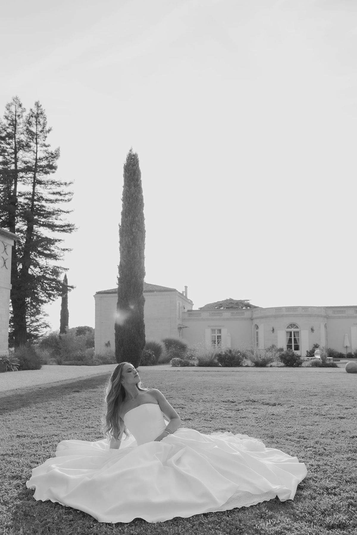 Kendra seated on the lawn with her skirt spread around her, Château Gassies behind