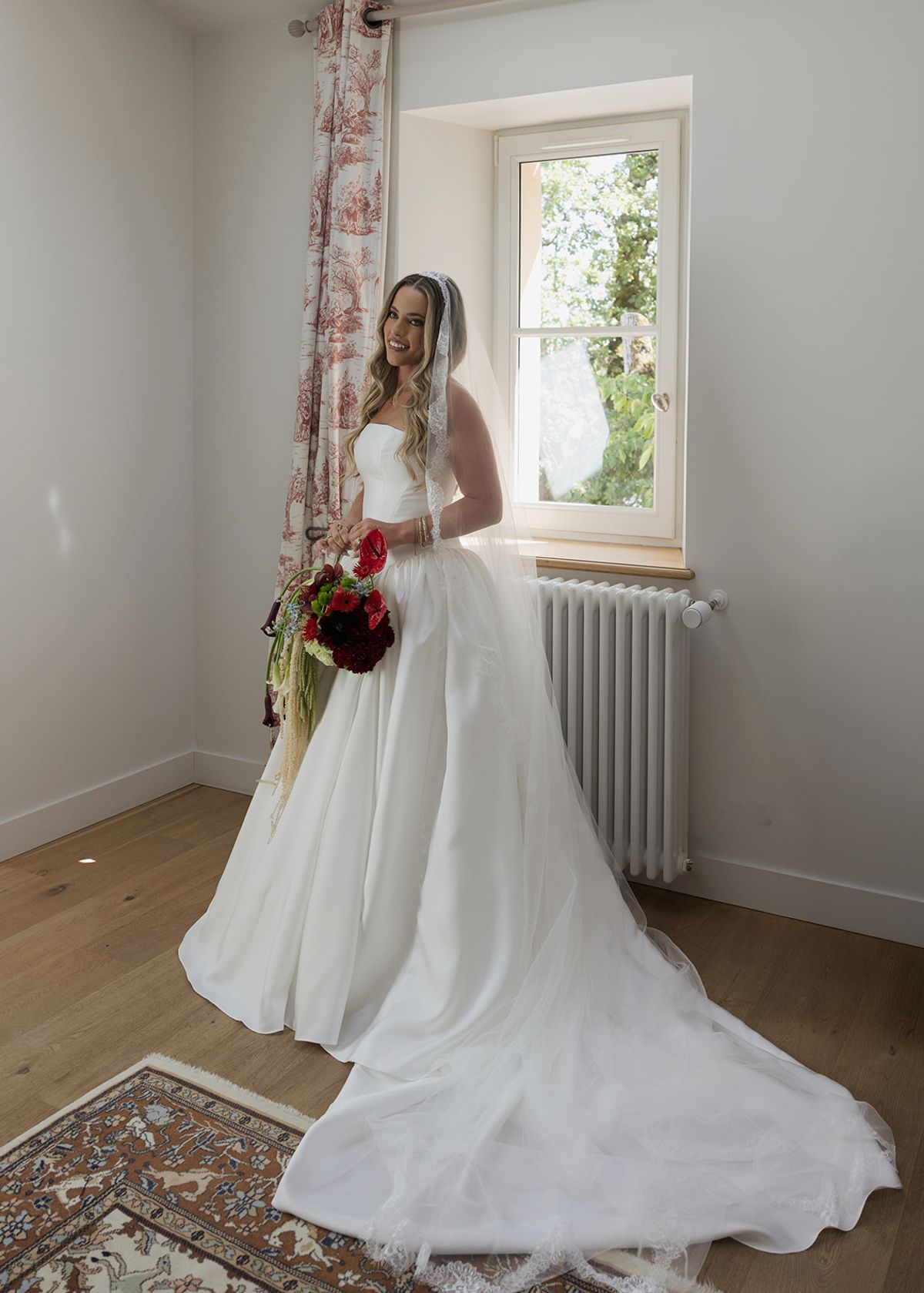Kendra holding her bouquet in her room