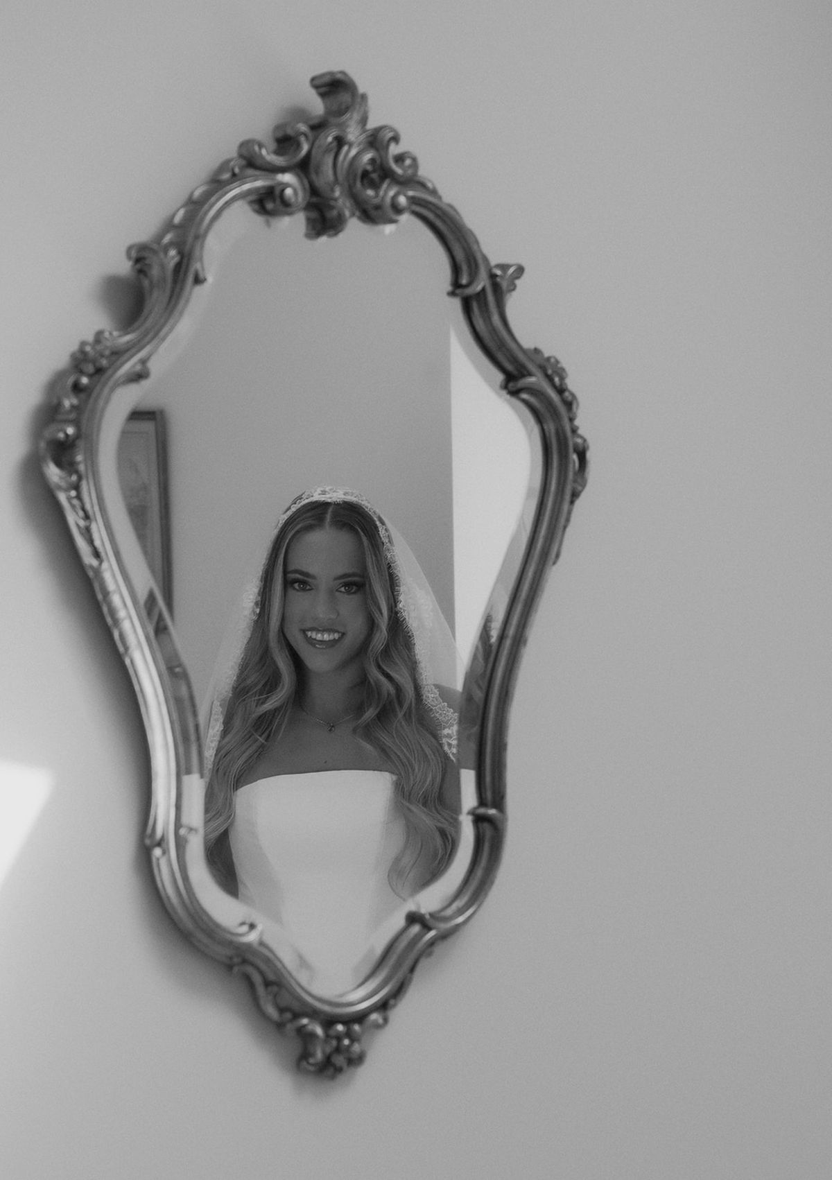 Kendra reflected in an ornate mirror, black and white