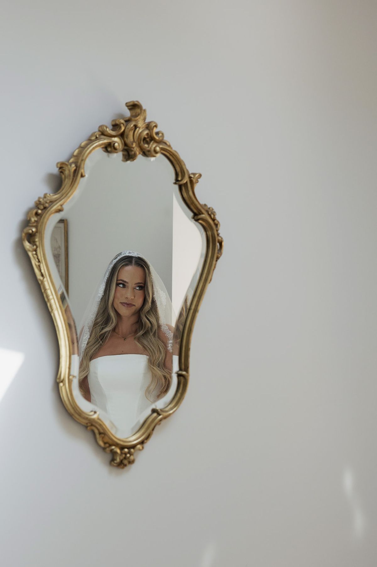Kendra reflected in a gilded rococo mirror