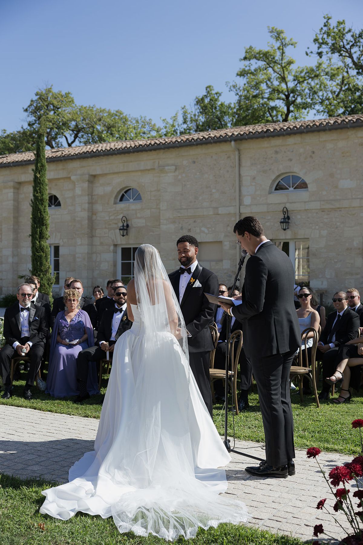The officiant speaking as Kendra and Brandon face each other at the ceremony