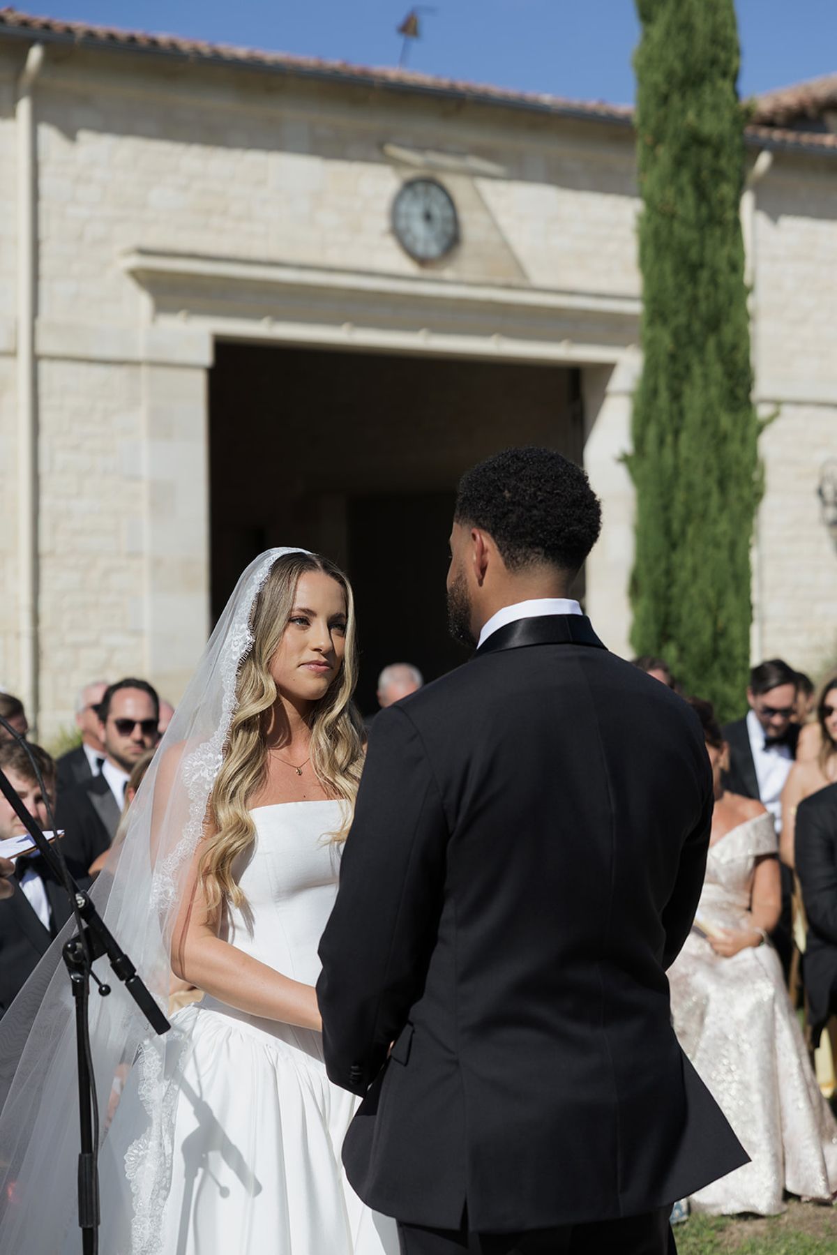Kendra and Brandon at the ceremony in front of the château clock tower