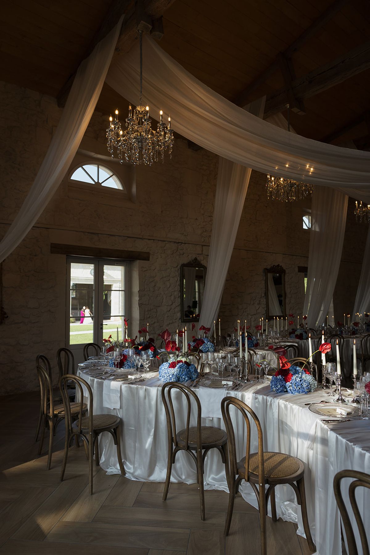 The reception room with white drapery, chandeliers and round tables