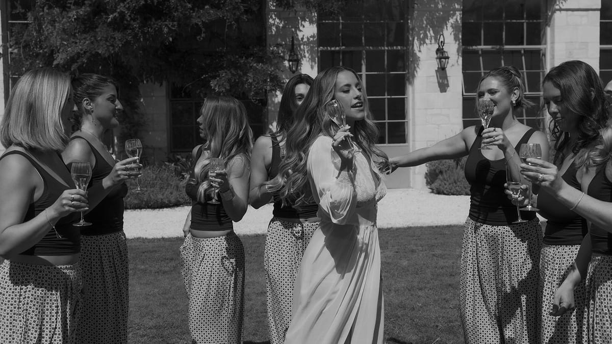 Kendra and friends raising glasses on the lawn, black and white
