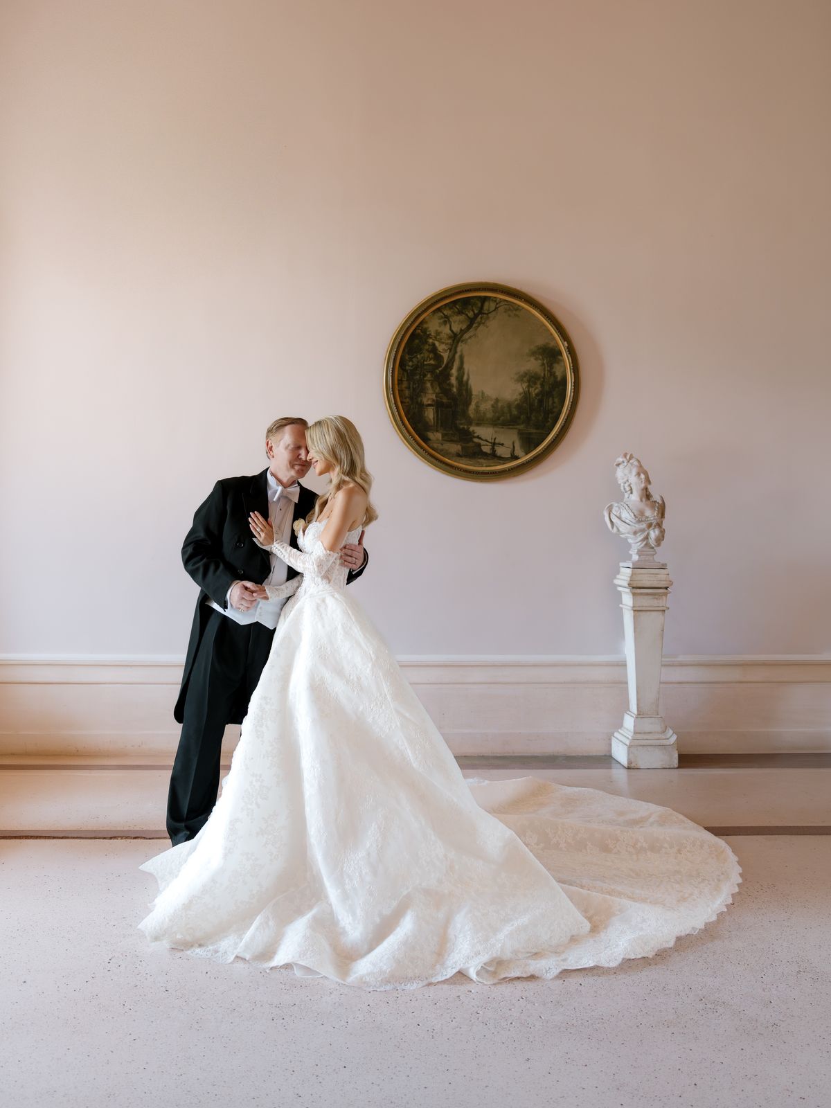 Kira and Steve embrace in a pale pink salon at Chateau Challain