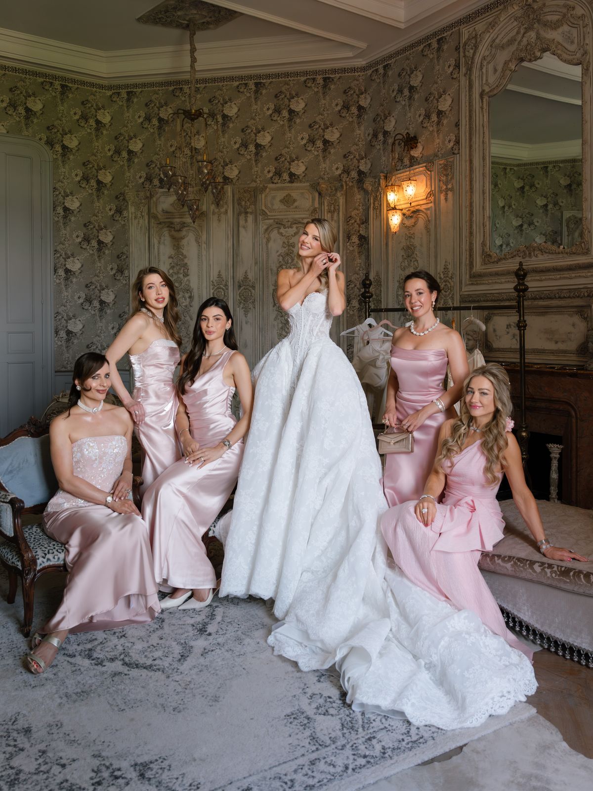 Kira with her bridesmaids in pink satin in a panelled salon at Chateau Challain