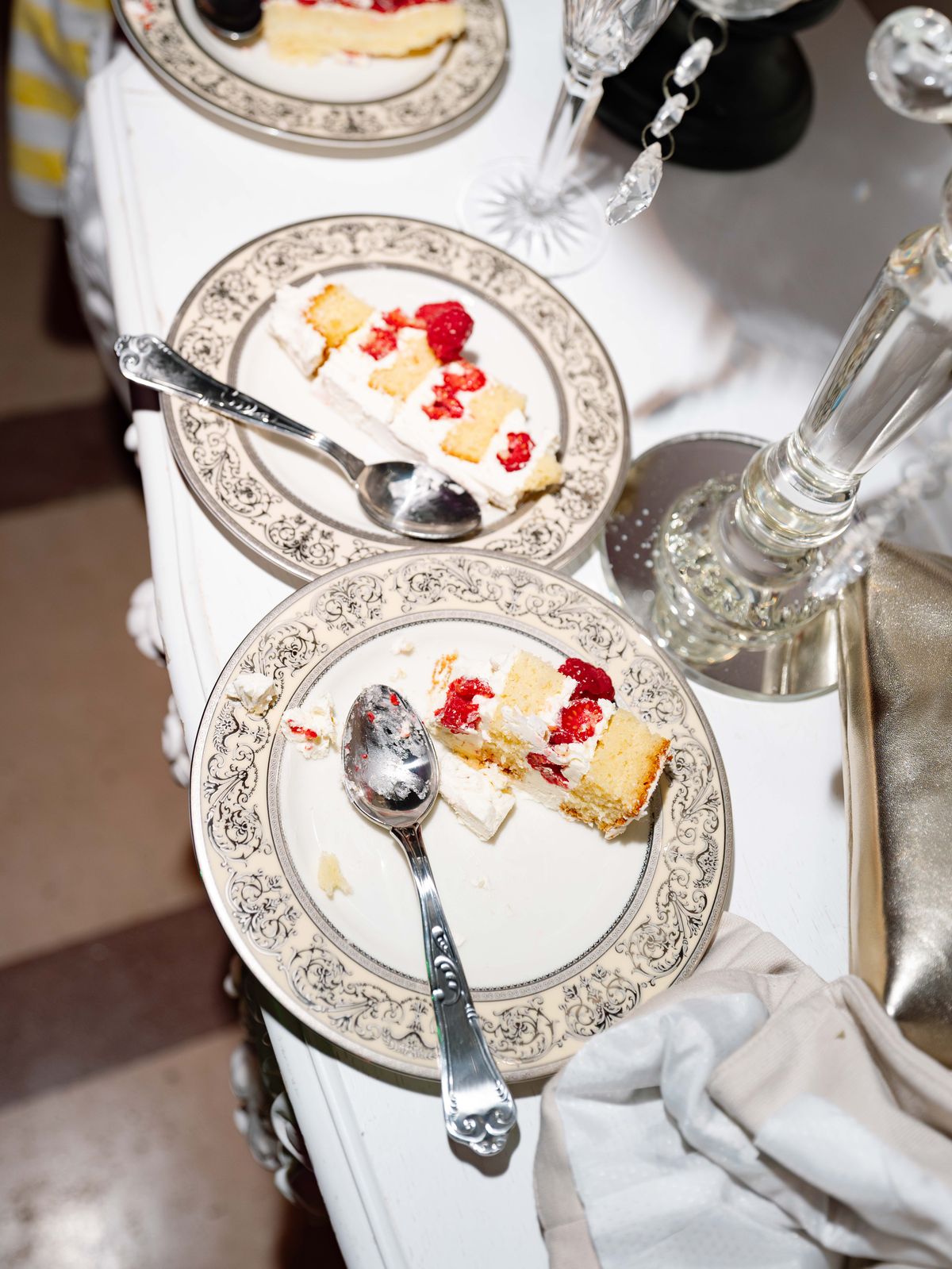 Plates of raspberry wedding cake on a silver-rimmed tablecloth at Chateau Challain