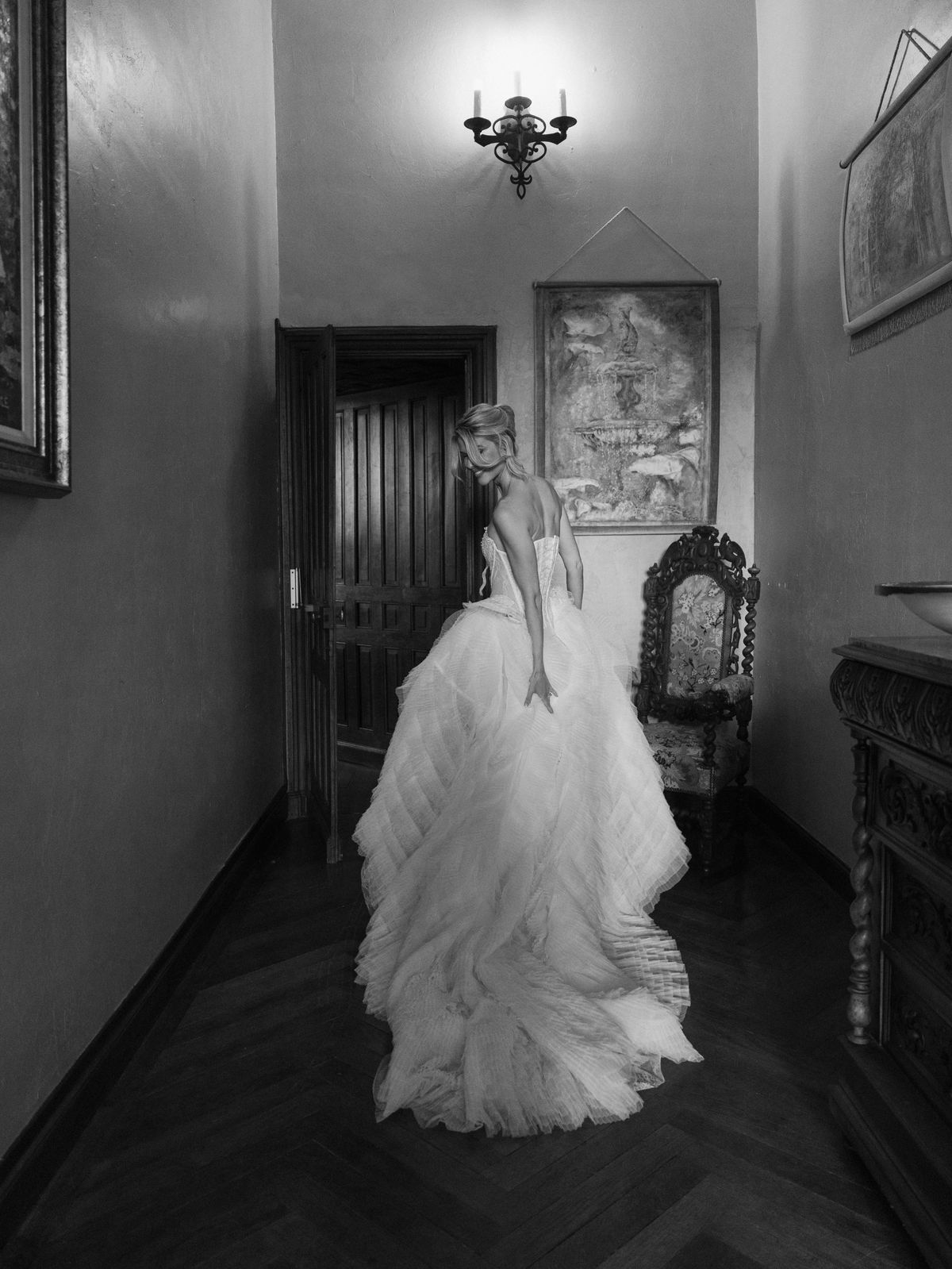 Kira in a ruffled tulle gown in a wood-panelled corridor at Chateau Challain