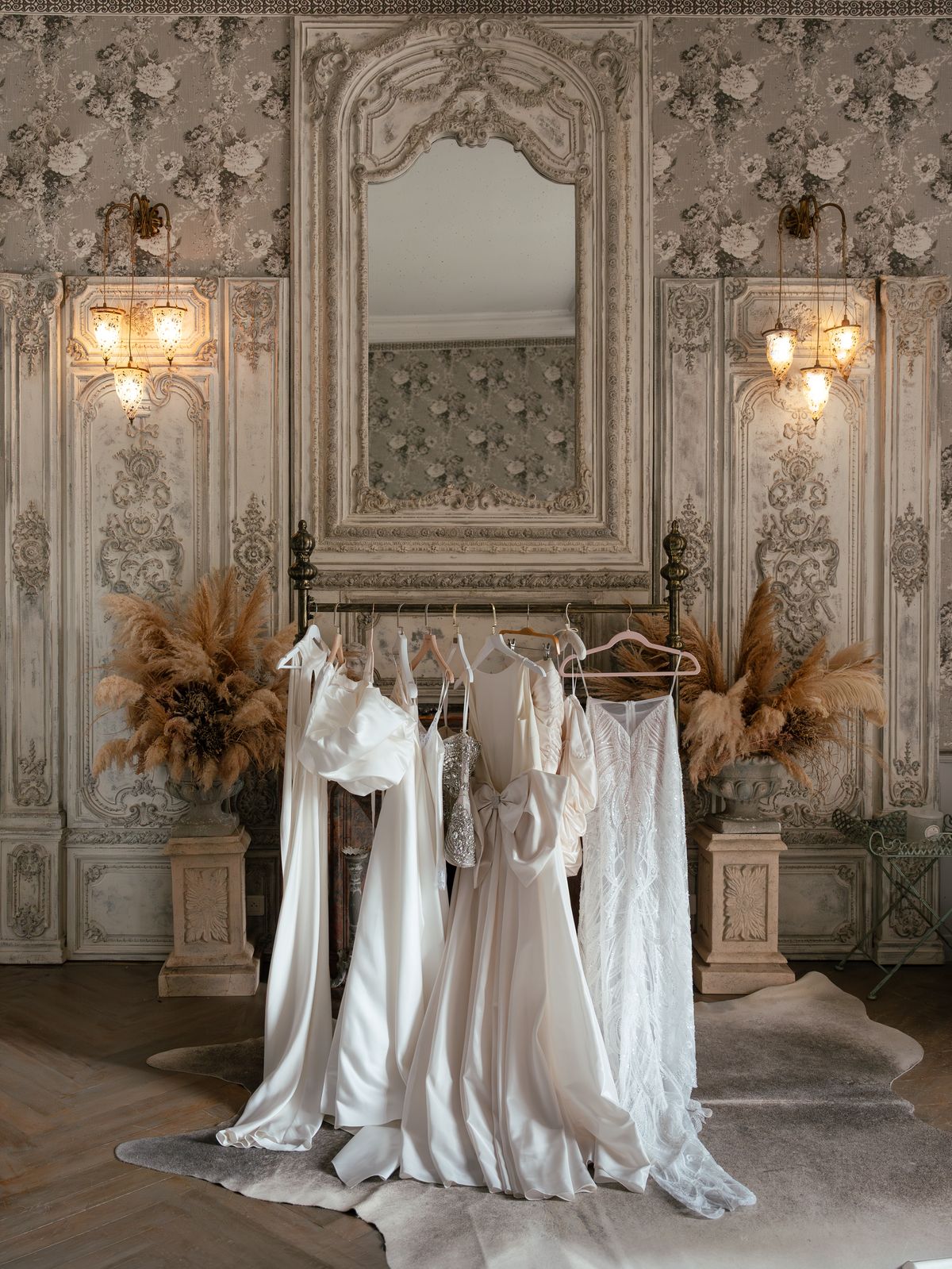A rail of Kira's bridal looks in a panelled salon at Chateau Challain