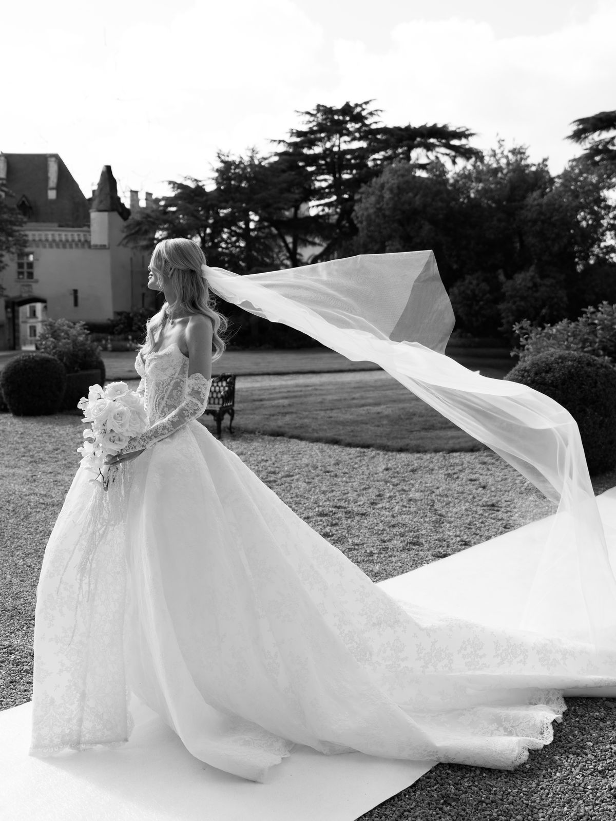Kira's cathedral veil lifts in the breeze on the lawn at Chateau Challain