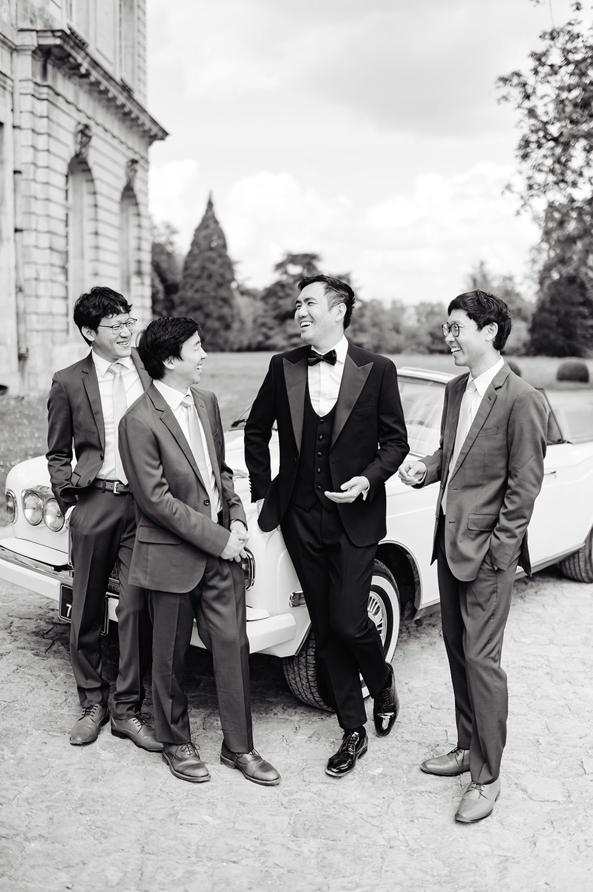 Ruiji laughing with his groomsmen while getting ready, black and white