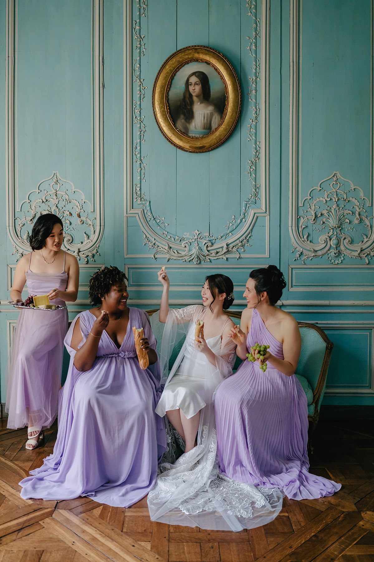Bridesmaids seated together laughing in the bridal suite
