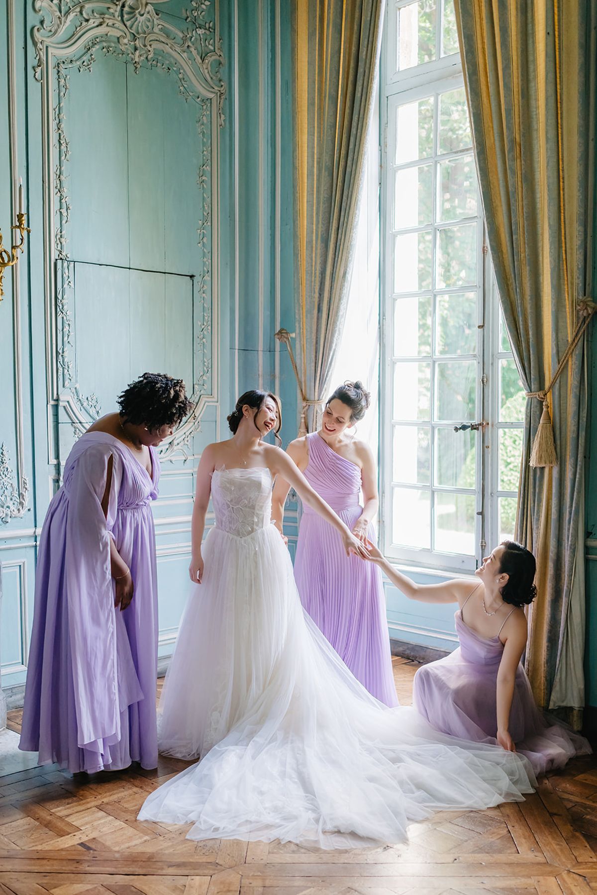 Bridesmaids helping Liana into her dress in the blue panelled room