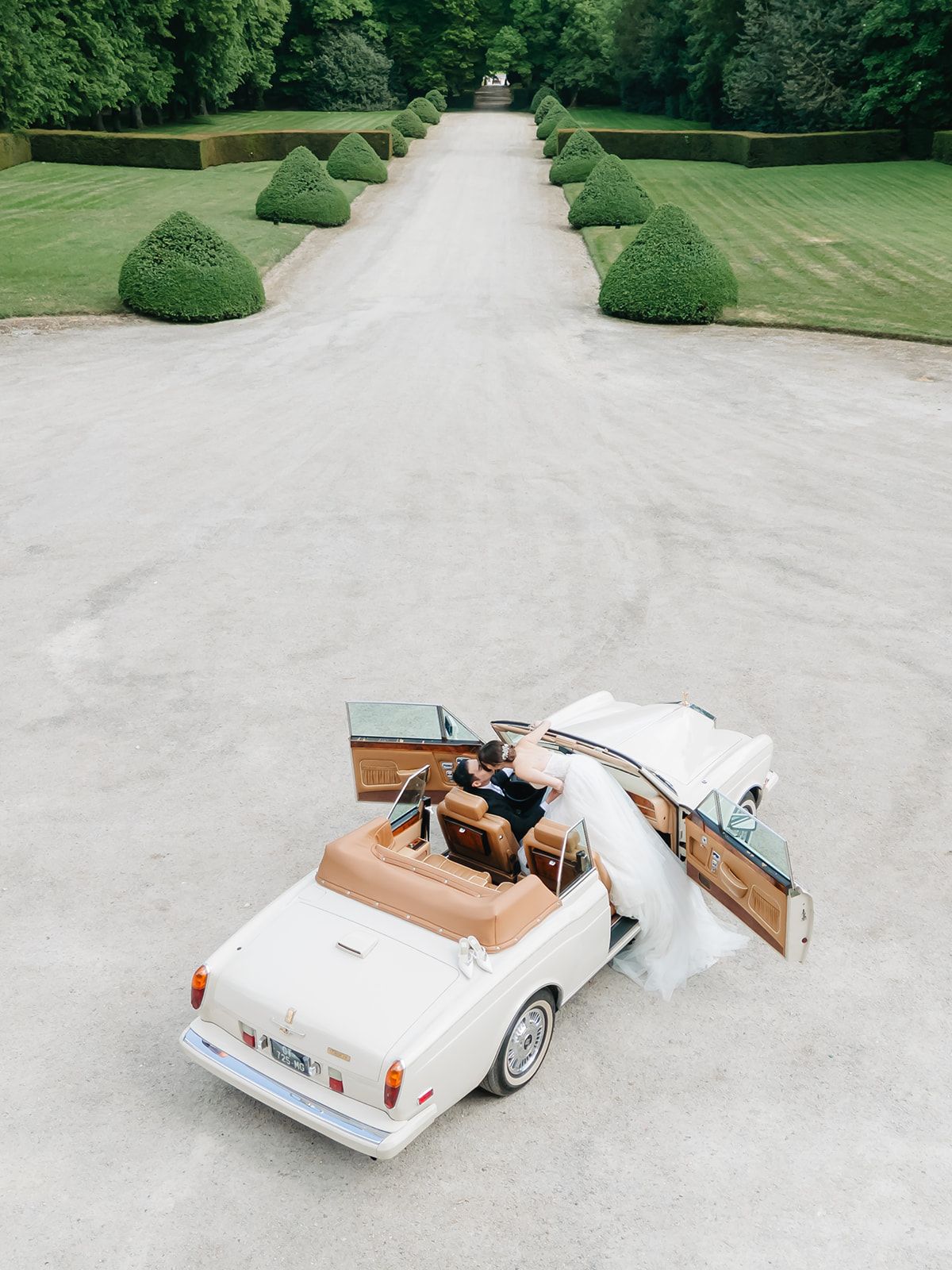 Liana and Ruiji together in a vintage convertible, overhead angle