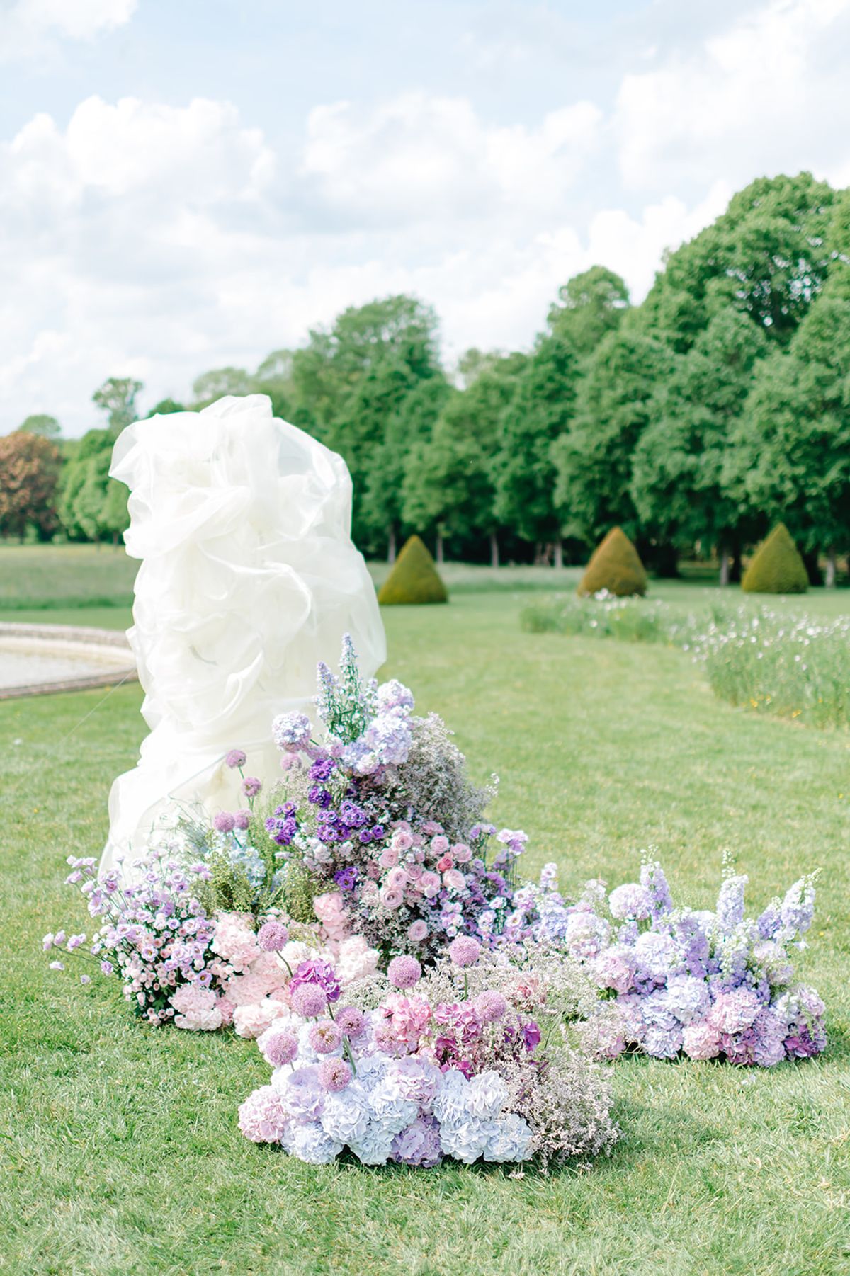 The white sculptural floral installation among the garden hedges
